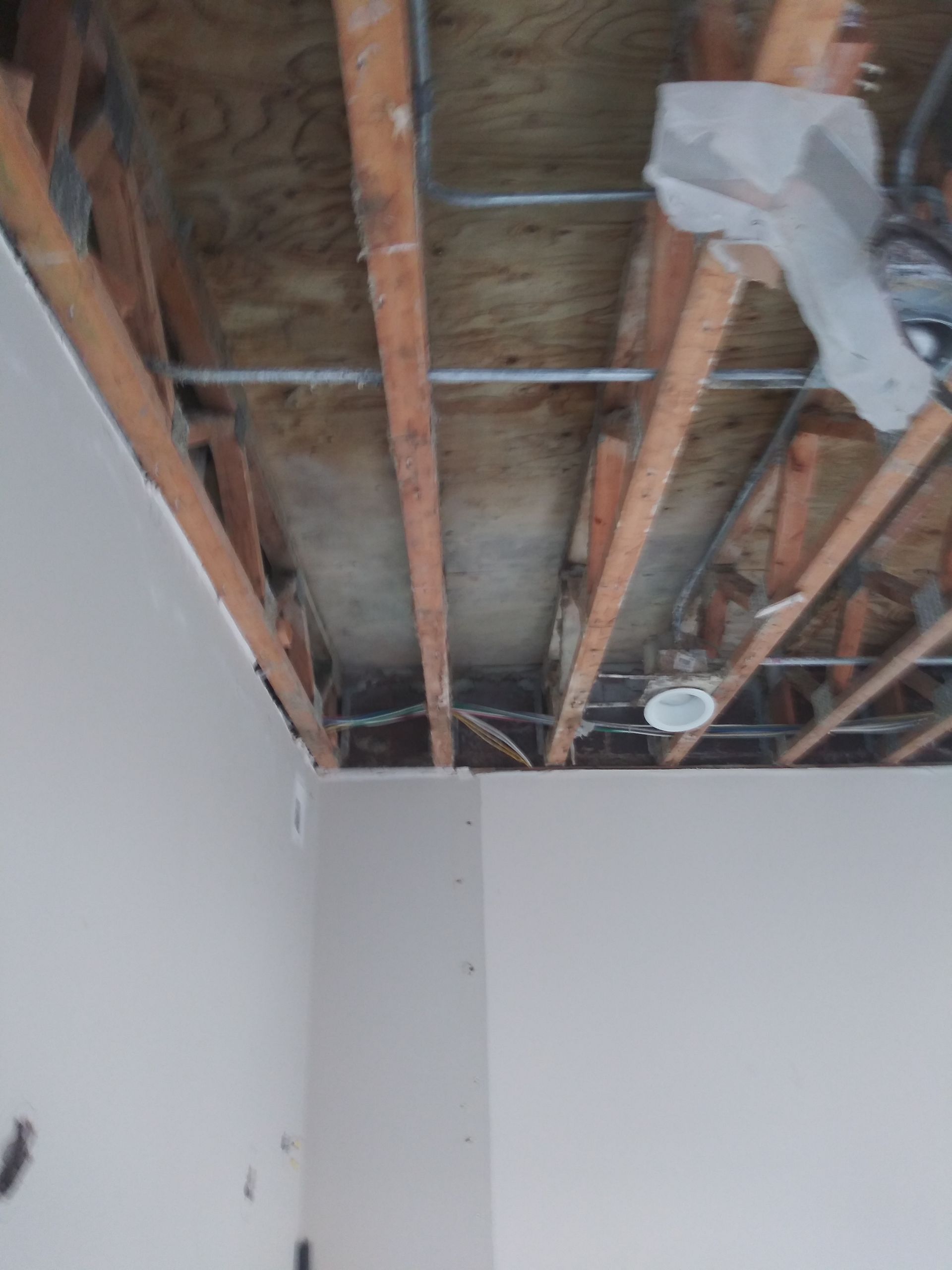 The ceiling of a room with a ceiling fan hanging from it.