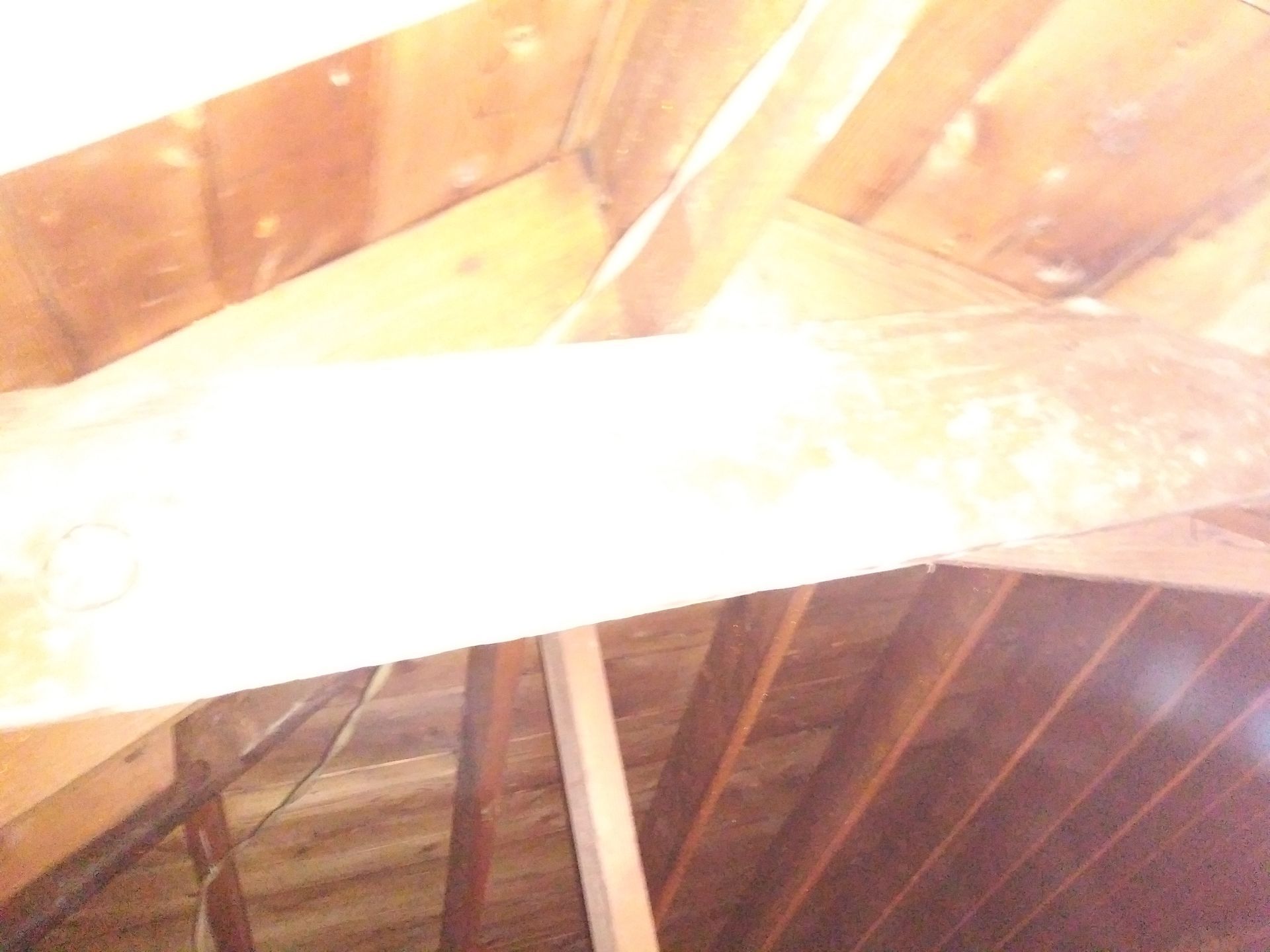 A wooden beam is hanging from the ceiling of a building