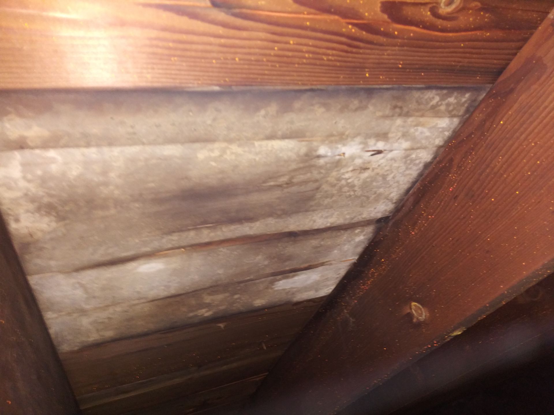 A close up of a wooden ceiling with a piece of insulation on it.