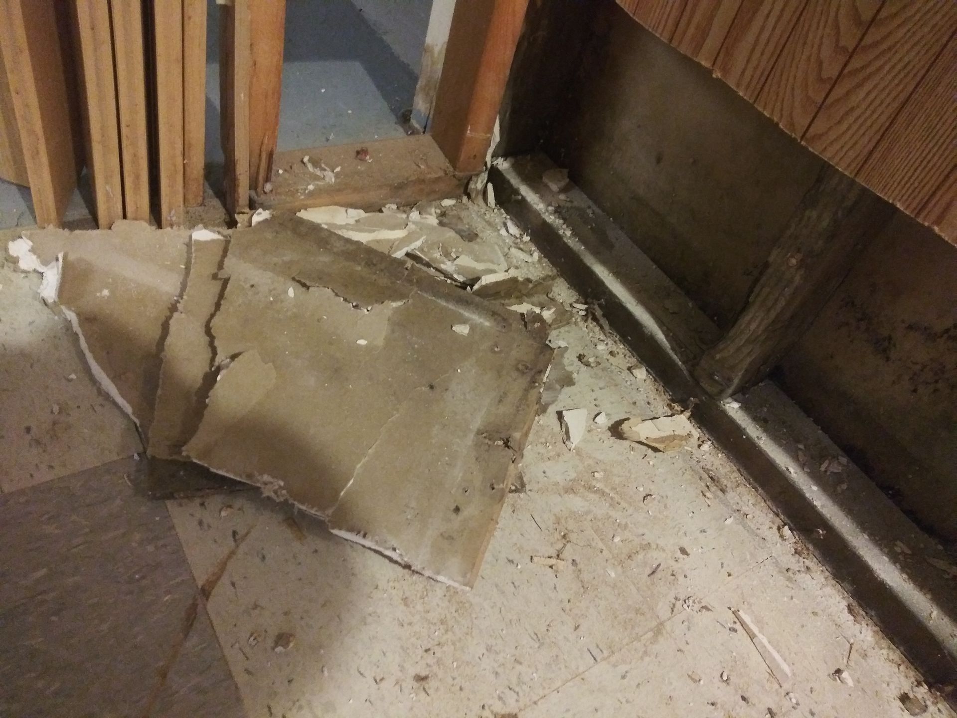 A piece of cardboard is laying on the floor next to a door.