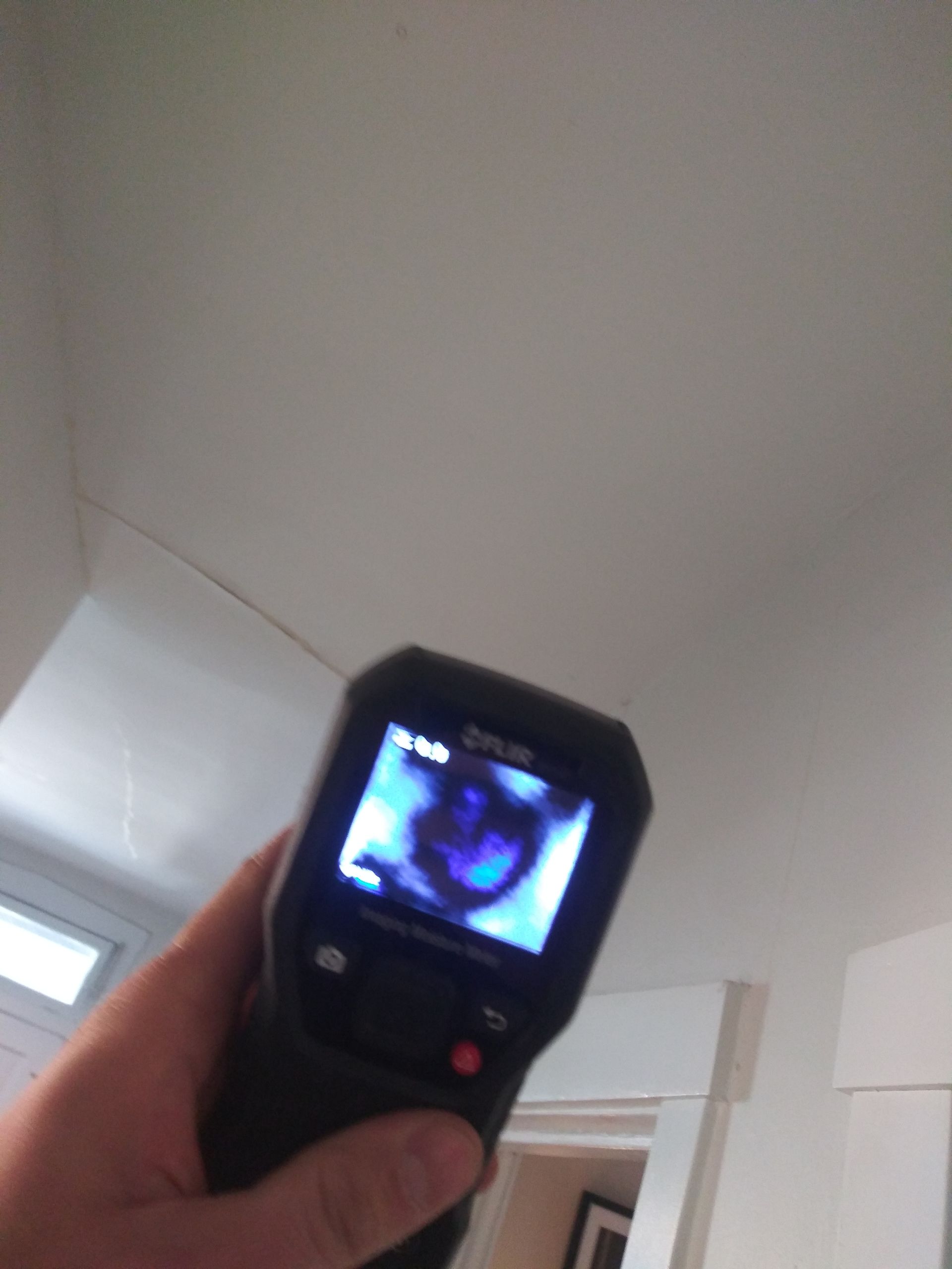 A person is holding a thermal camera in their hand