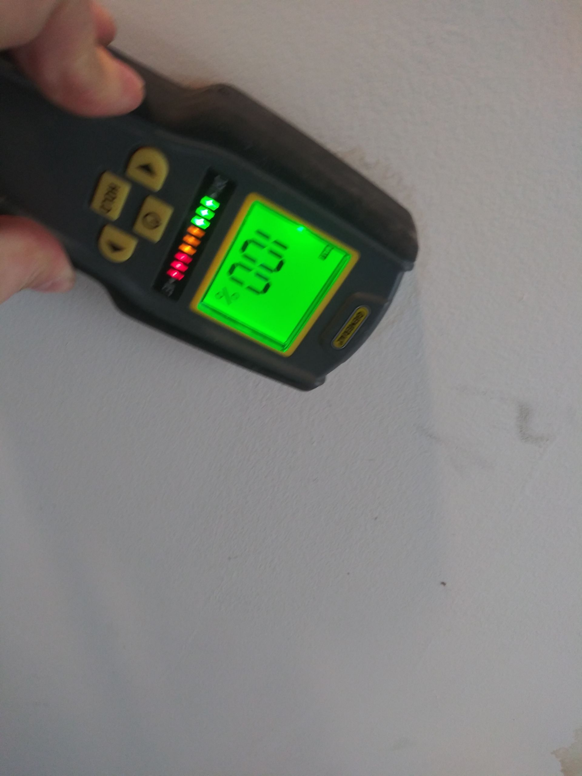 A person is holding a device with a green screen that says 100