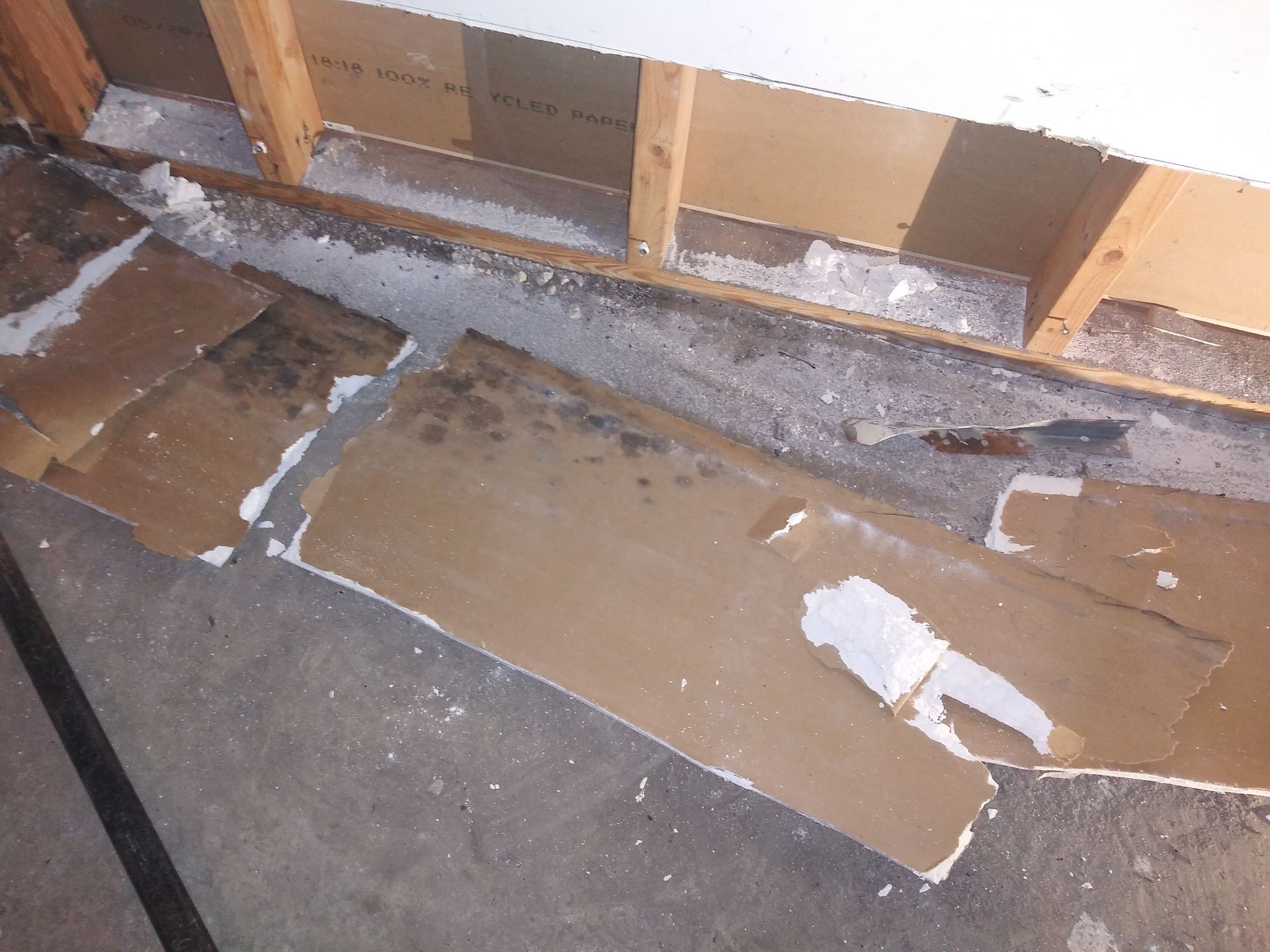 A piece of cardboard is laying on the floor next to a wall.