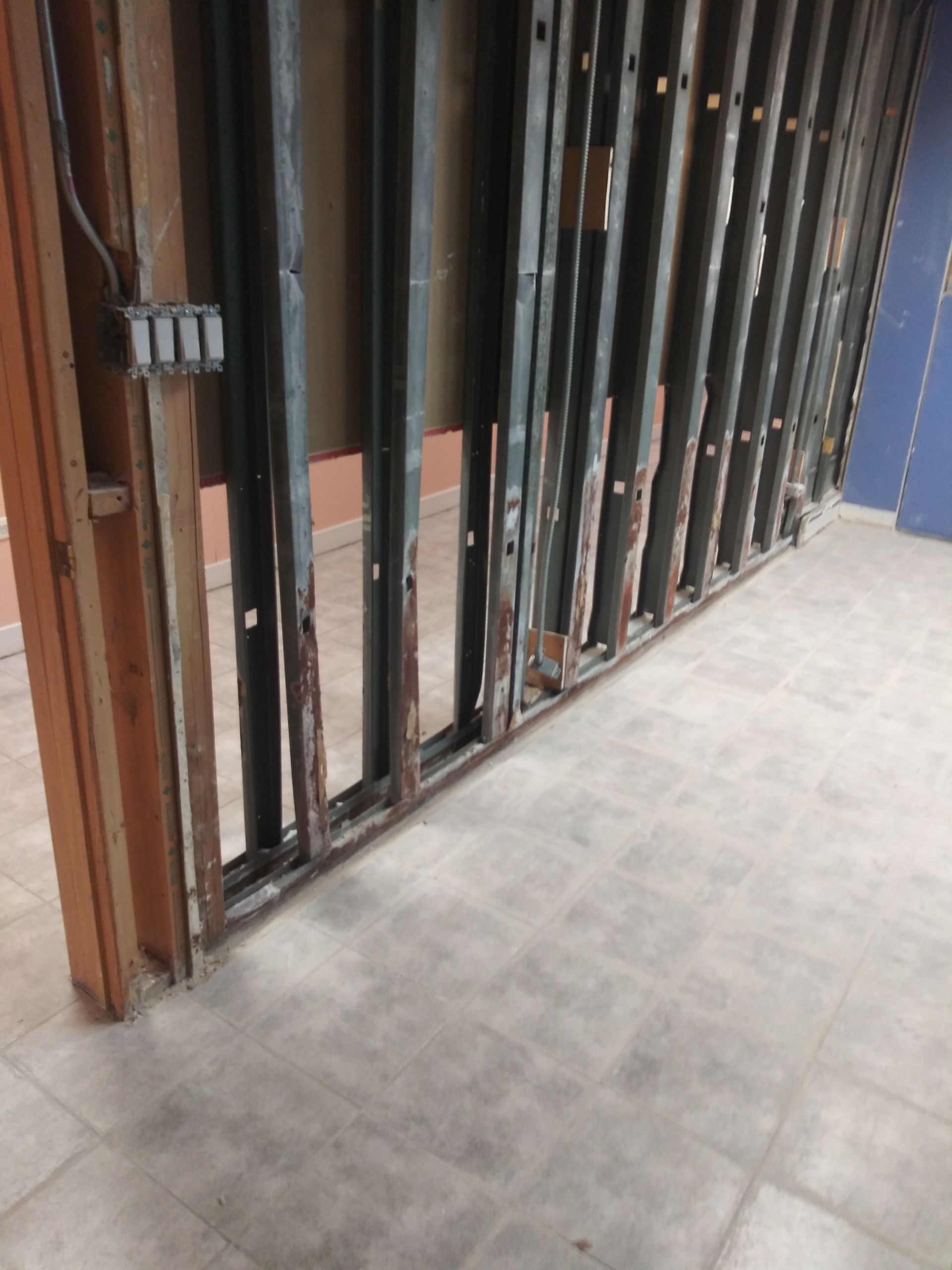 A room with a metal wall and a tiled floor