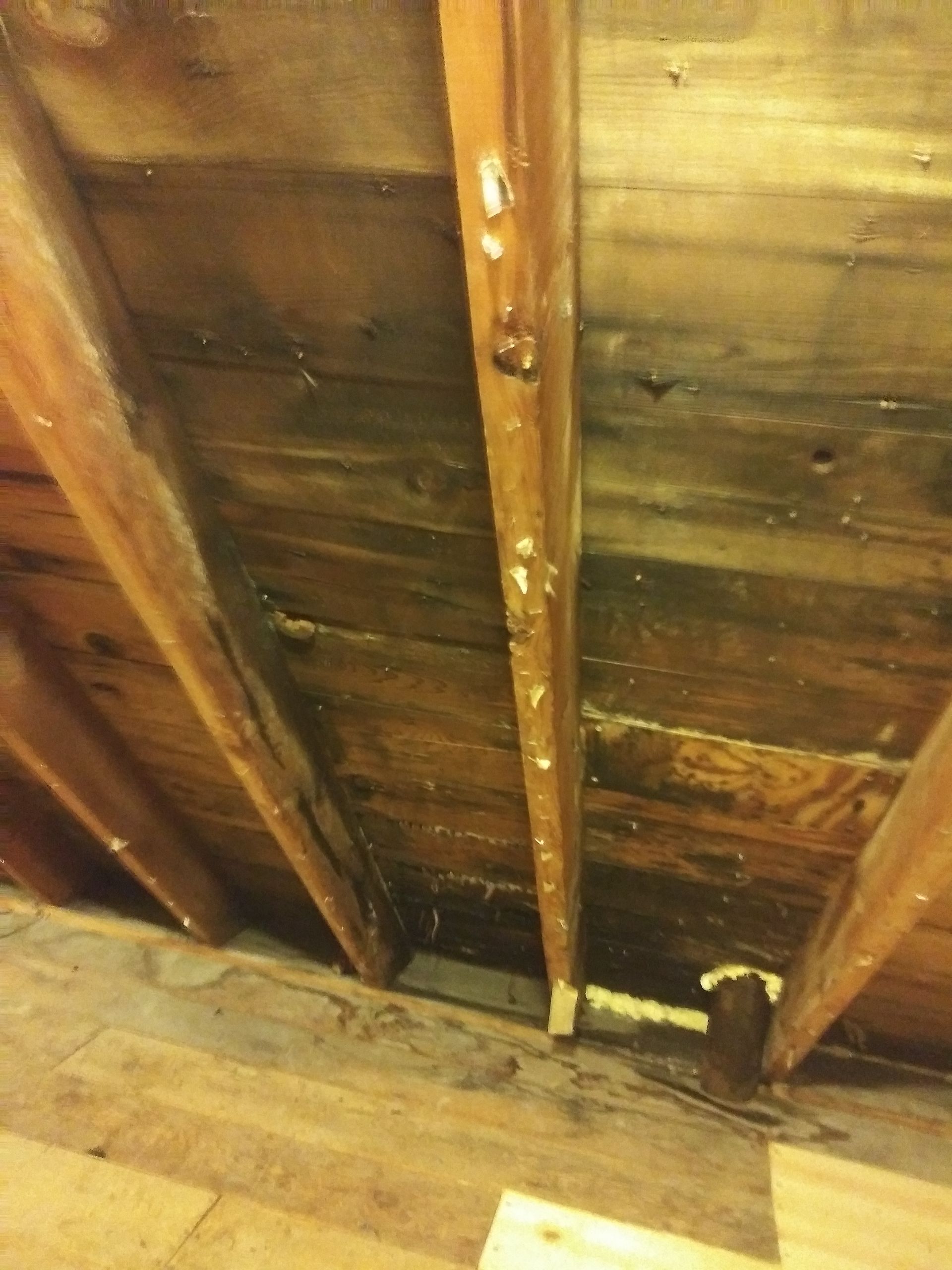 A close up of a wooden ceiling with a hole in it