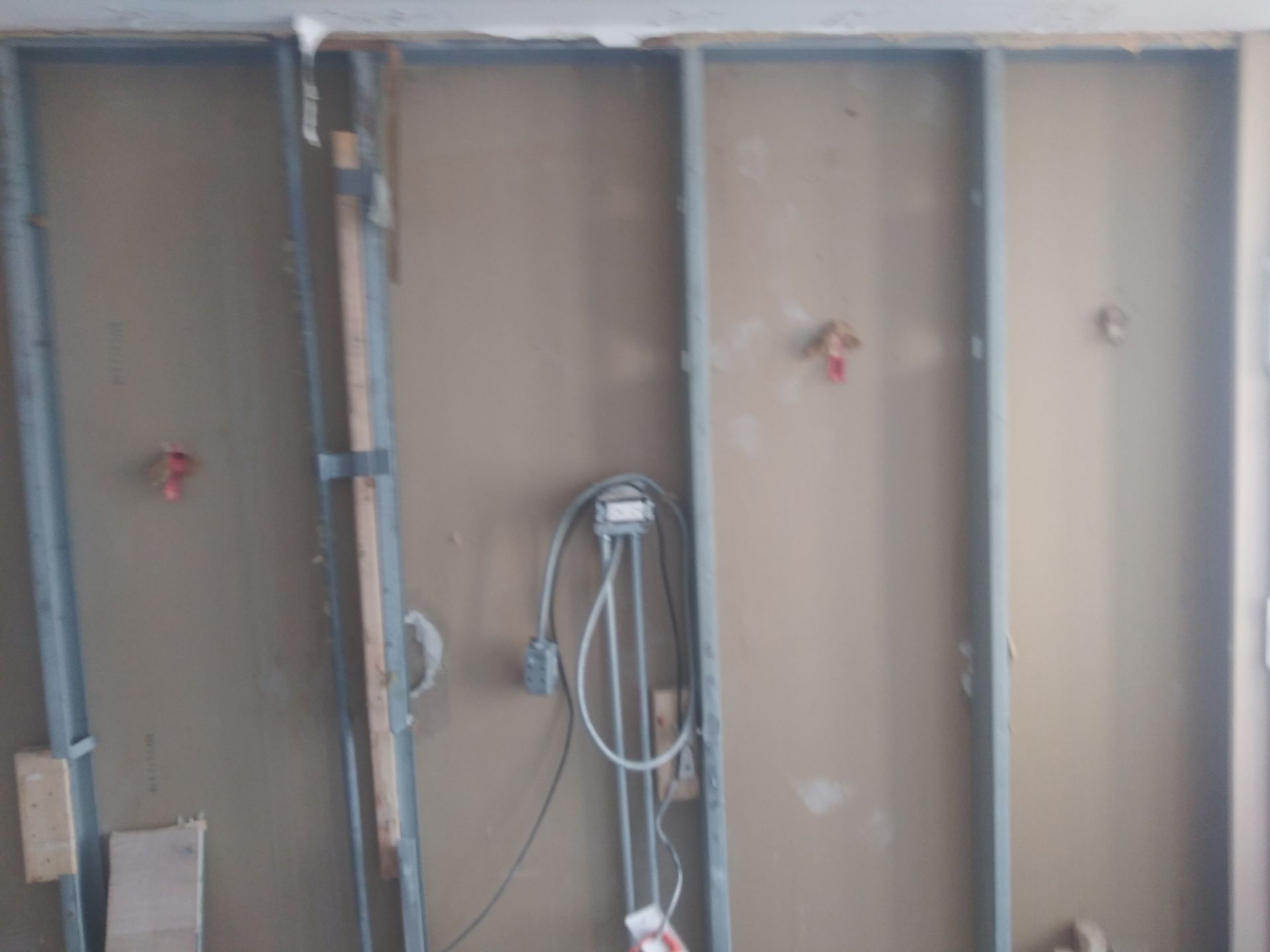 A wall with a lot of wires hanging from it.