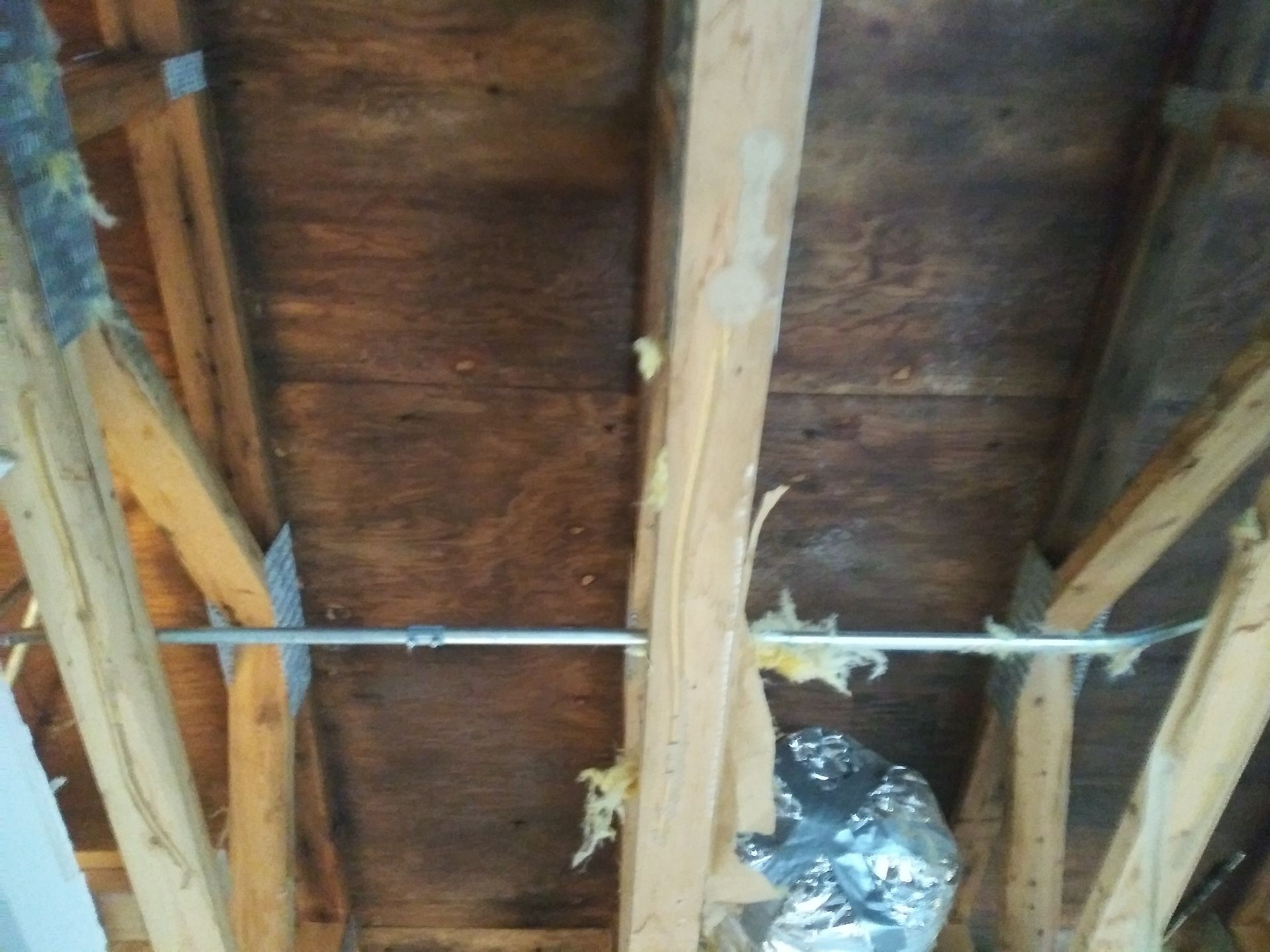 A wooden ceiling with a metal pipe coming out of it