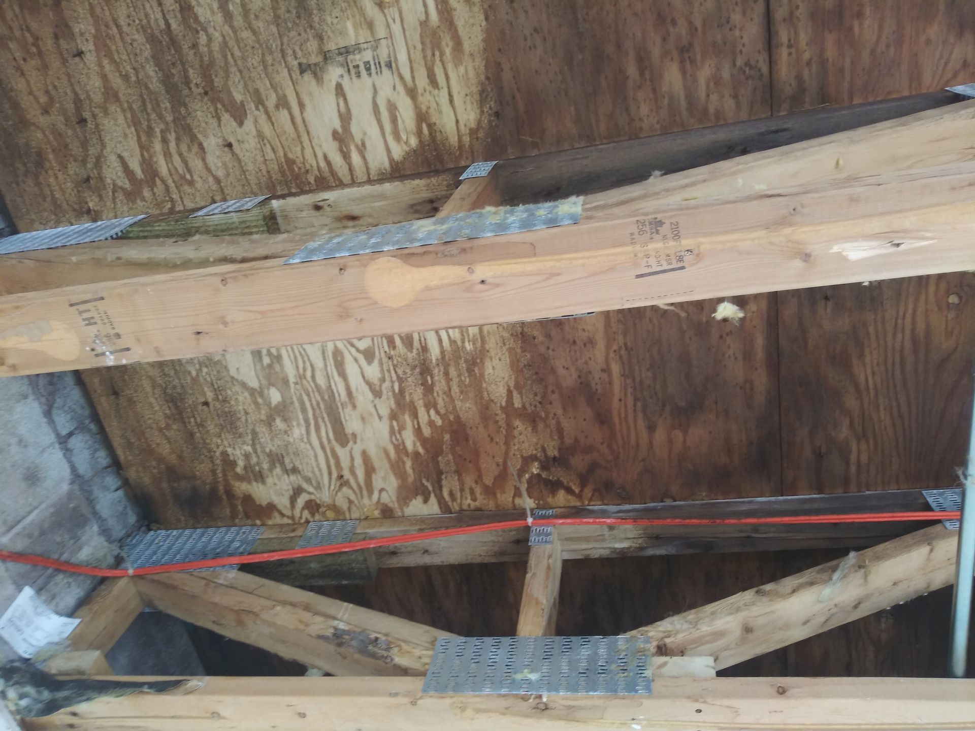 A close up of a wooden structure with a ladder in the background.
