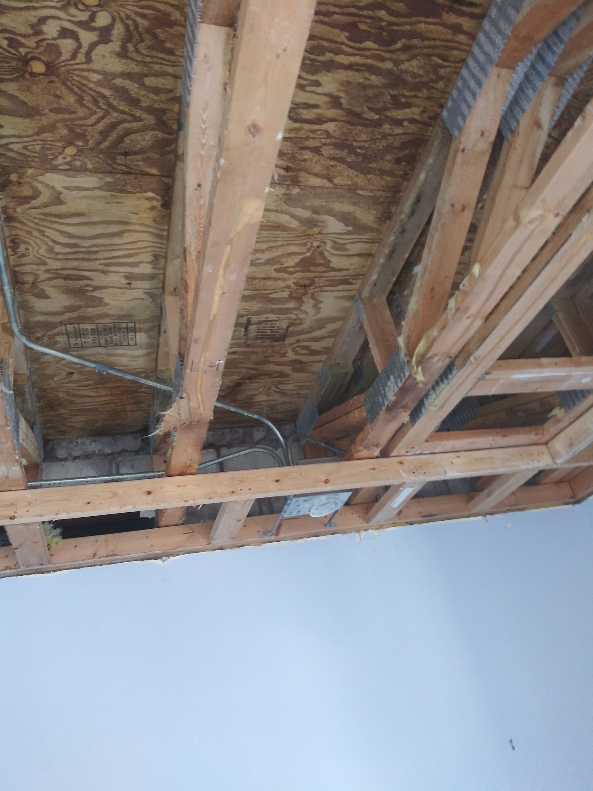 The ceiling of a building is being built and there is a hole in the ceiling.