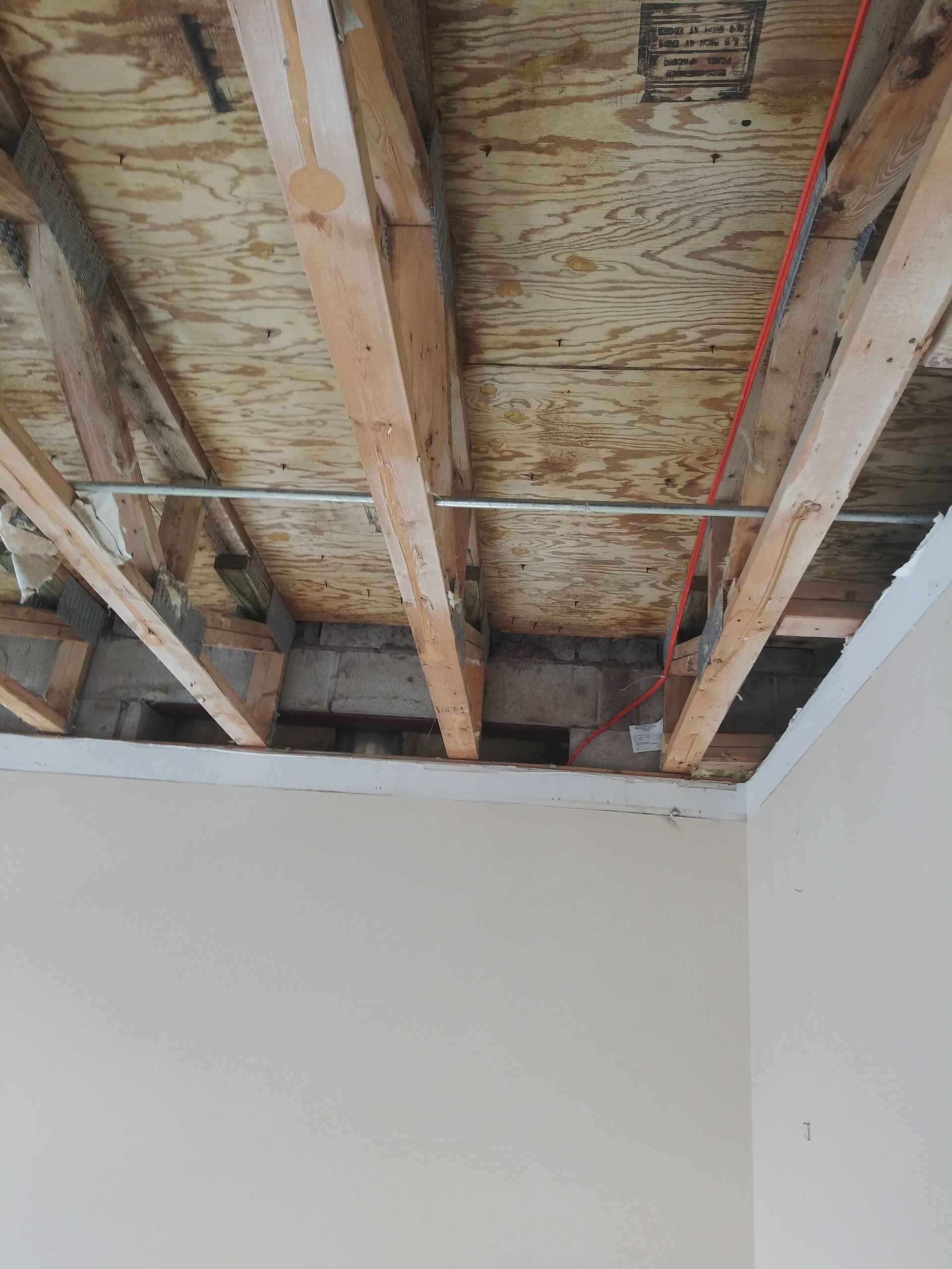 A room with a ceiling that is being remodeled with wooden beams.