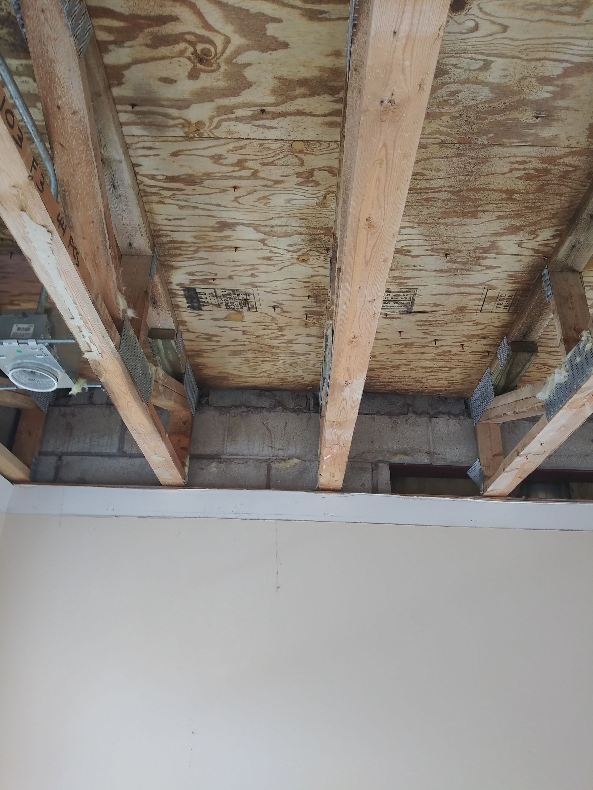 A room with a wooden ceiling and a brick wall.