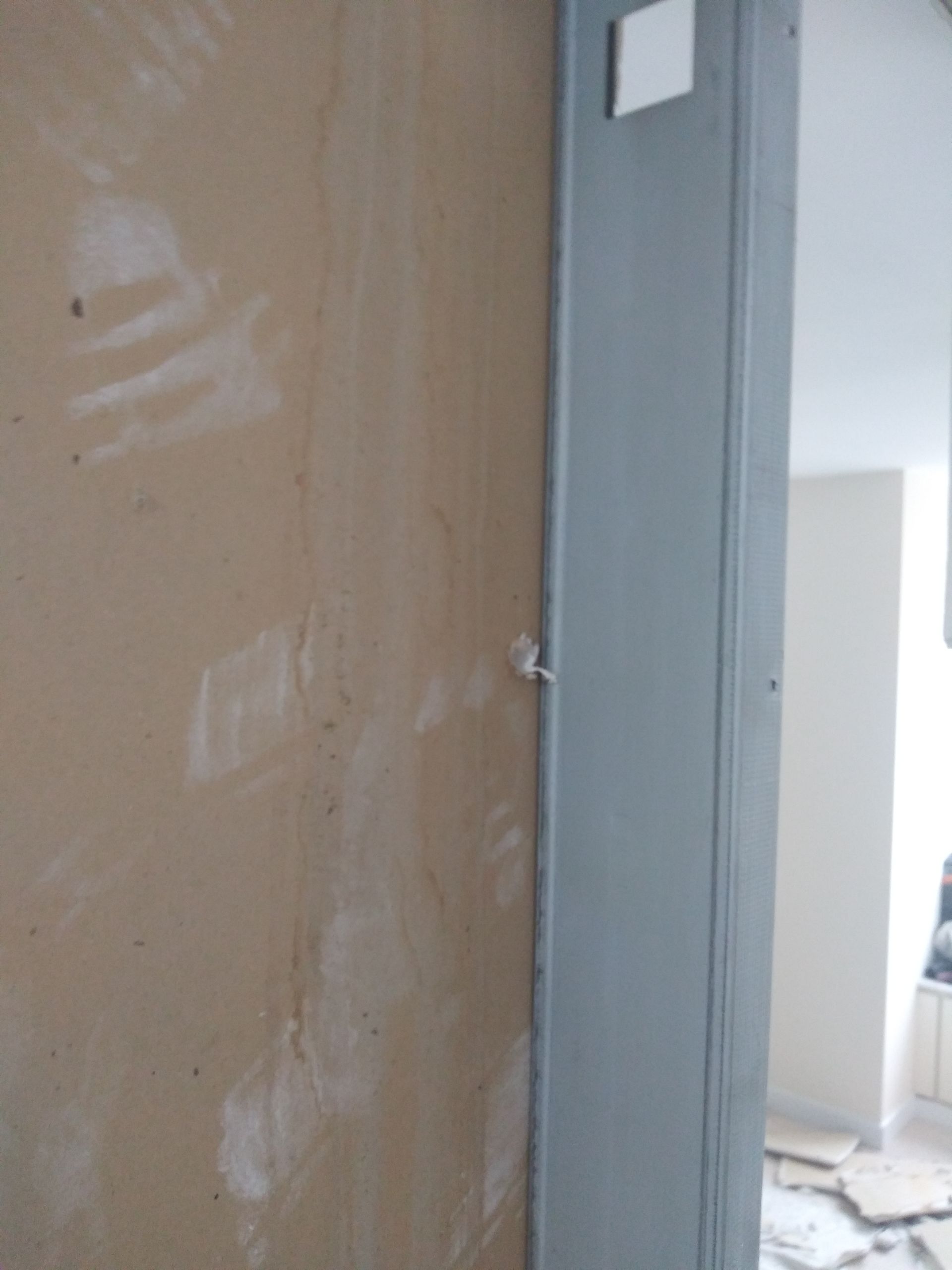 A door is being installed in a room with a gray trim.