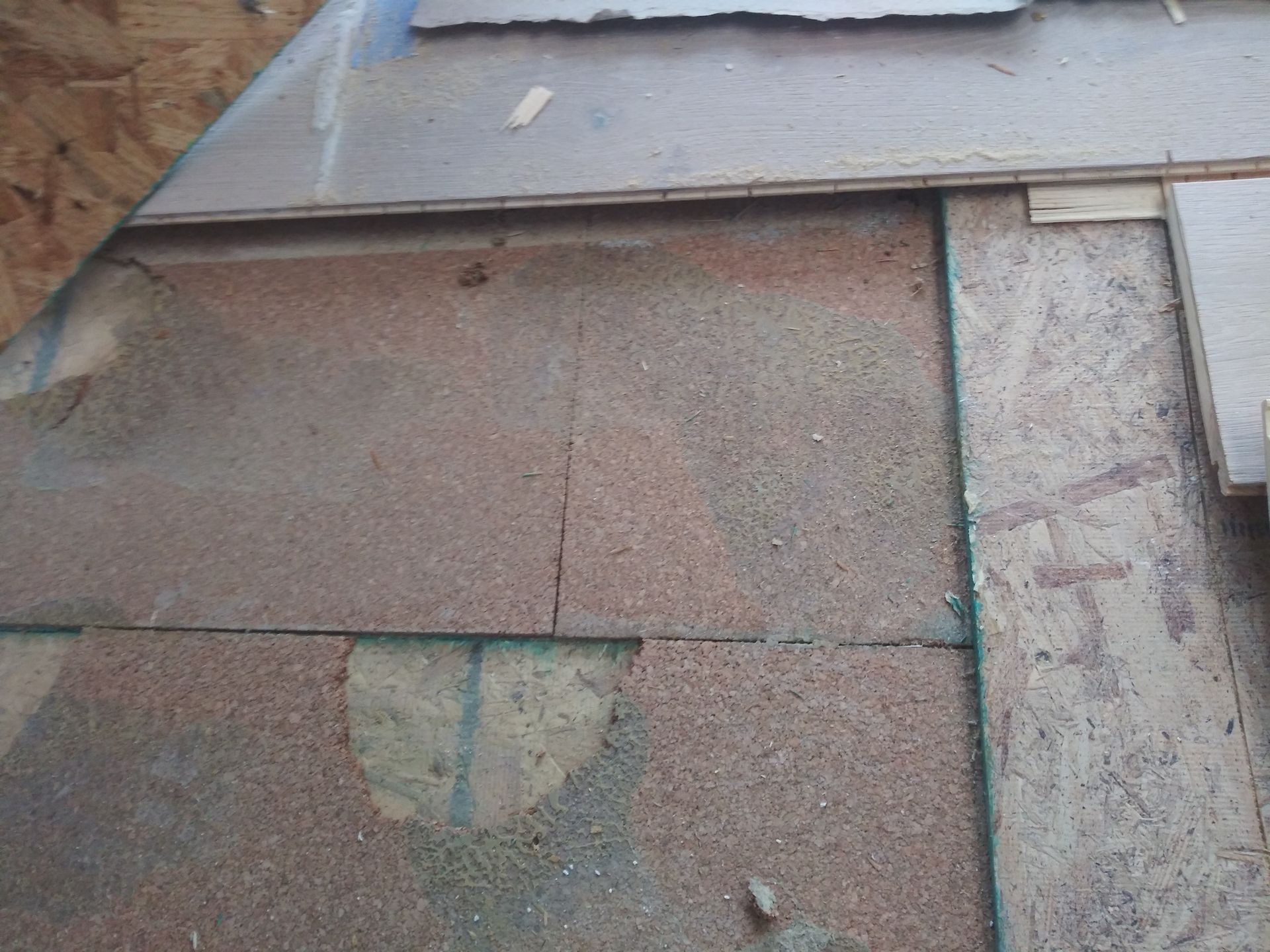 A piece of plywood is laying on a concrete surface.