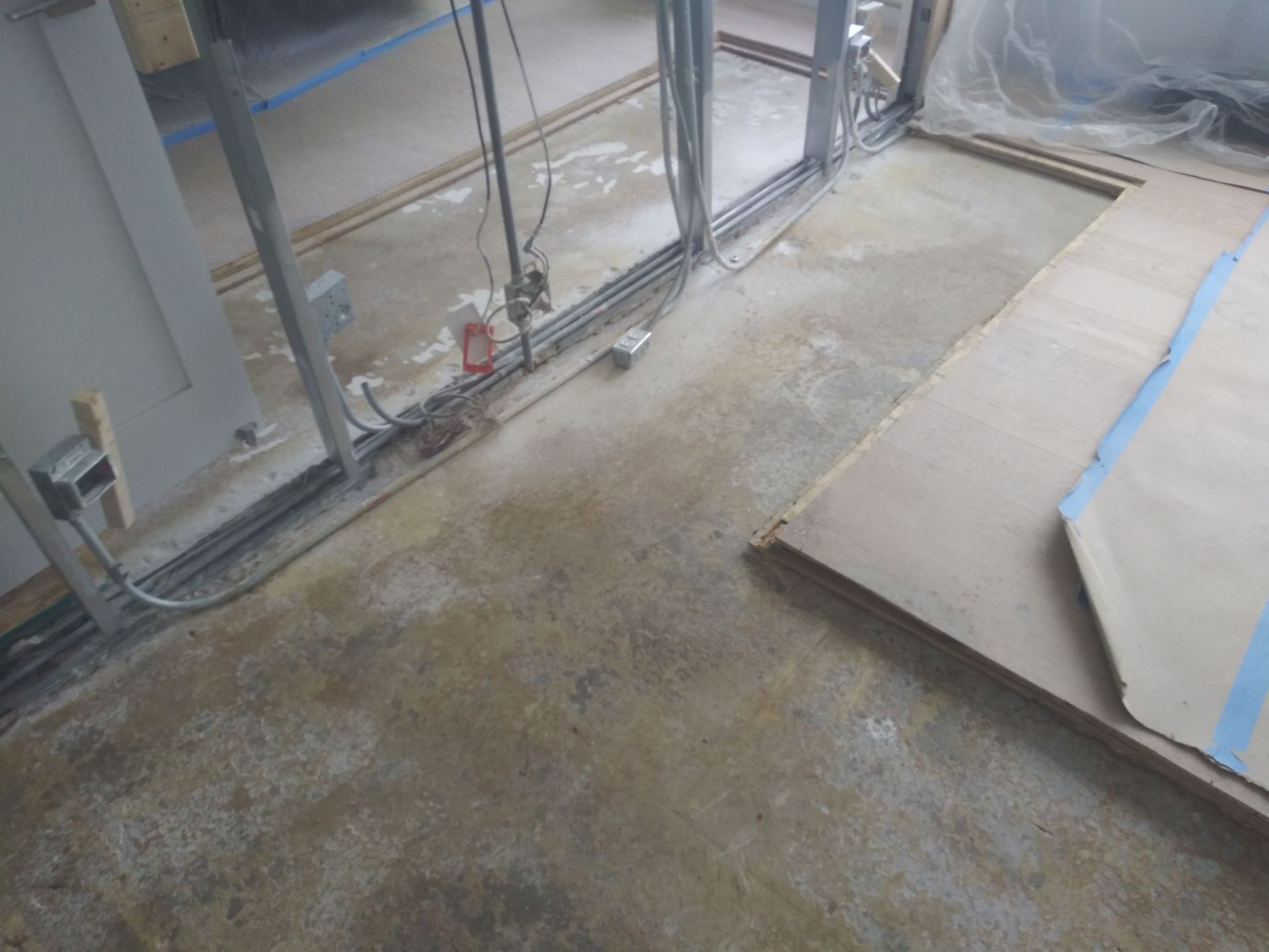 A room with a concrete floor and a wooden floor under construction.