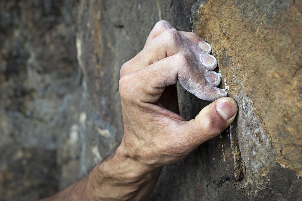 Rock Climber's Hand gripping small finger hold