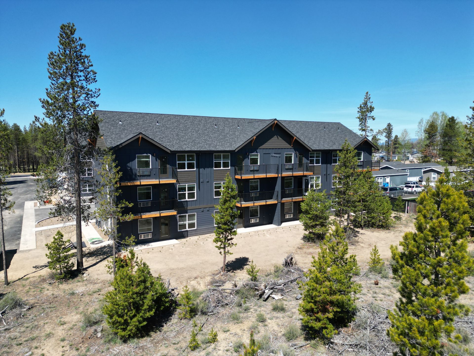 An aerial view of a large apartment building surrounded by trees.