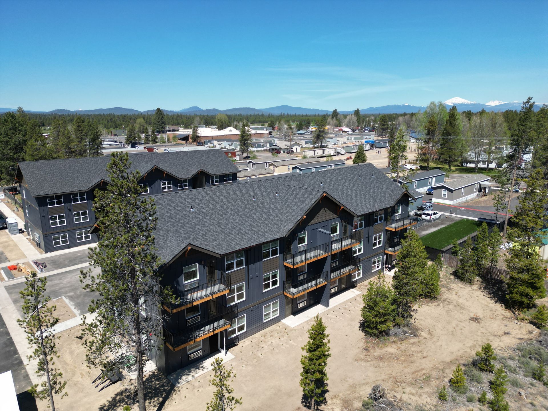 An aerial view of a large apartment building surrounded by trees.