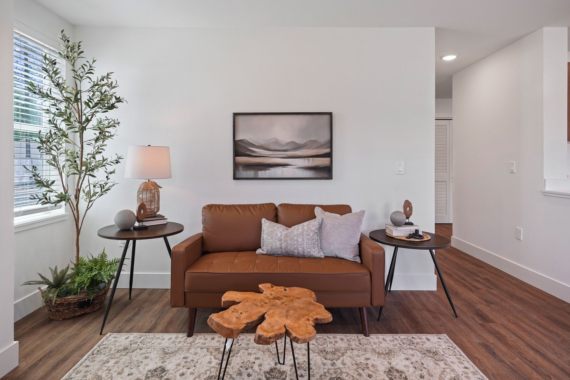 A living room with a brown couch and a wooden table