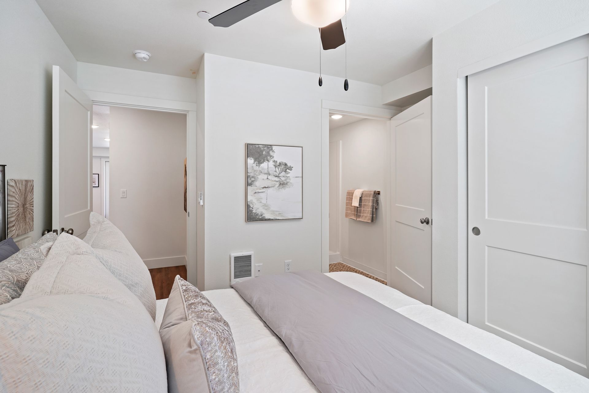 A bedroom with a bed and a ceiling fan.
