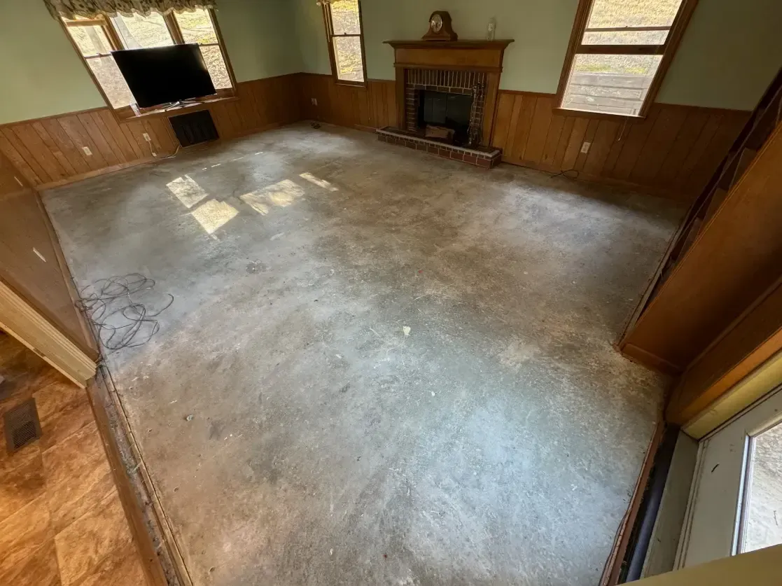 a living room with a concrete floor and a fireplace .