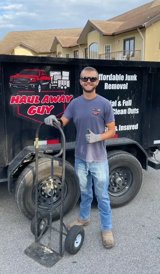 a man standing in front of a dumpster that says haul away guy