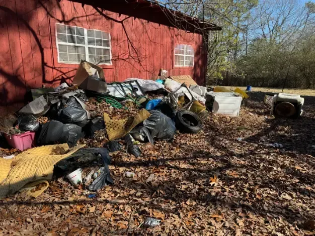 a pile of trash is sitting in front of a red building .