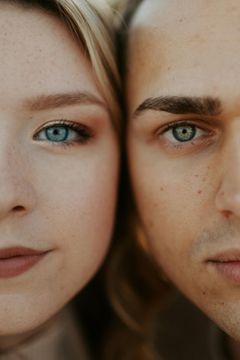 A close up of a man and a woman 's faces with blue eyes.