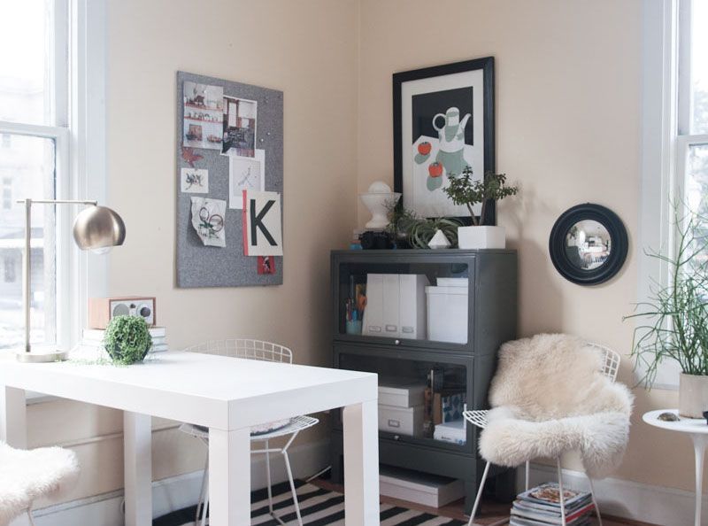 A room with a white table and chairs and a bulletin board with the letter k on it.