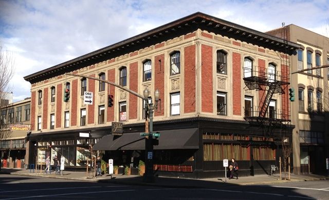 A large brick building on the corner of a city street
