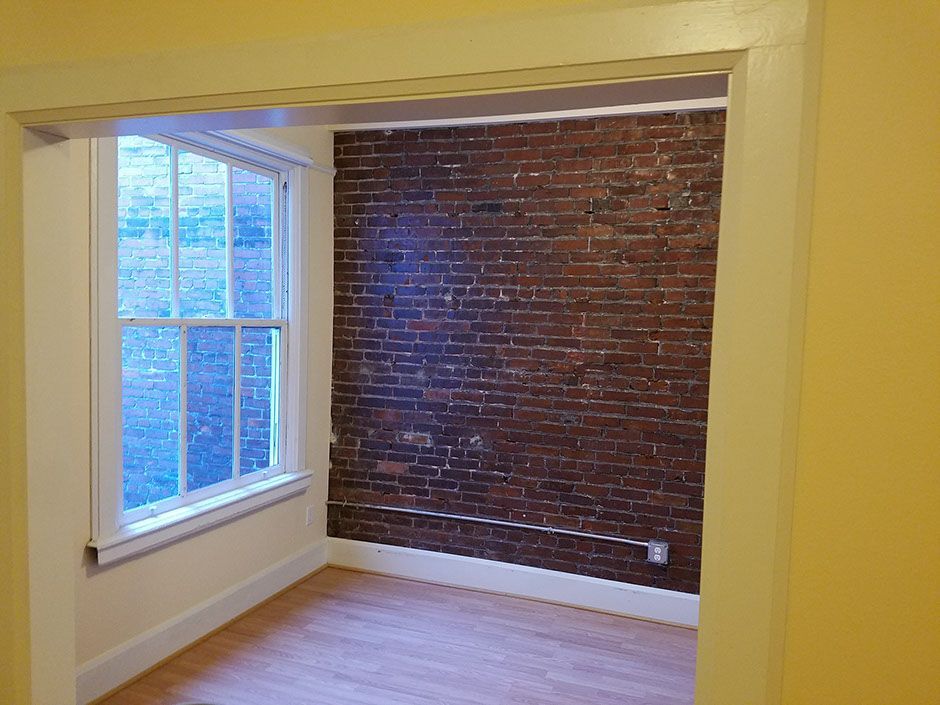 A room with a brick wall and a window