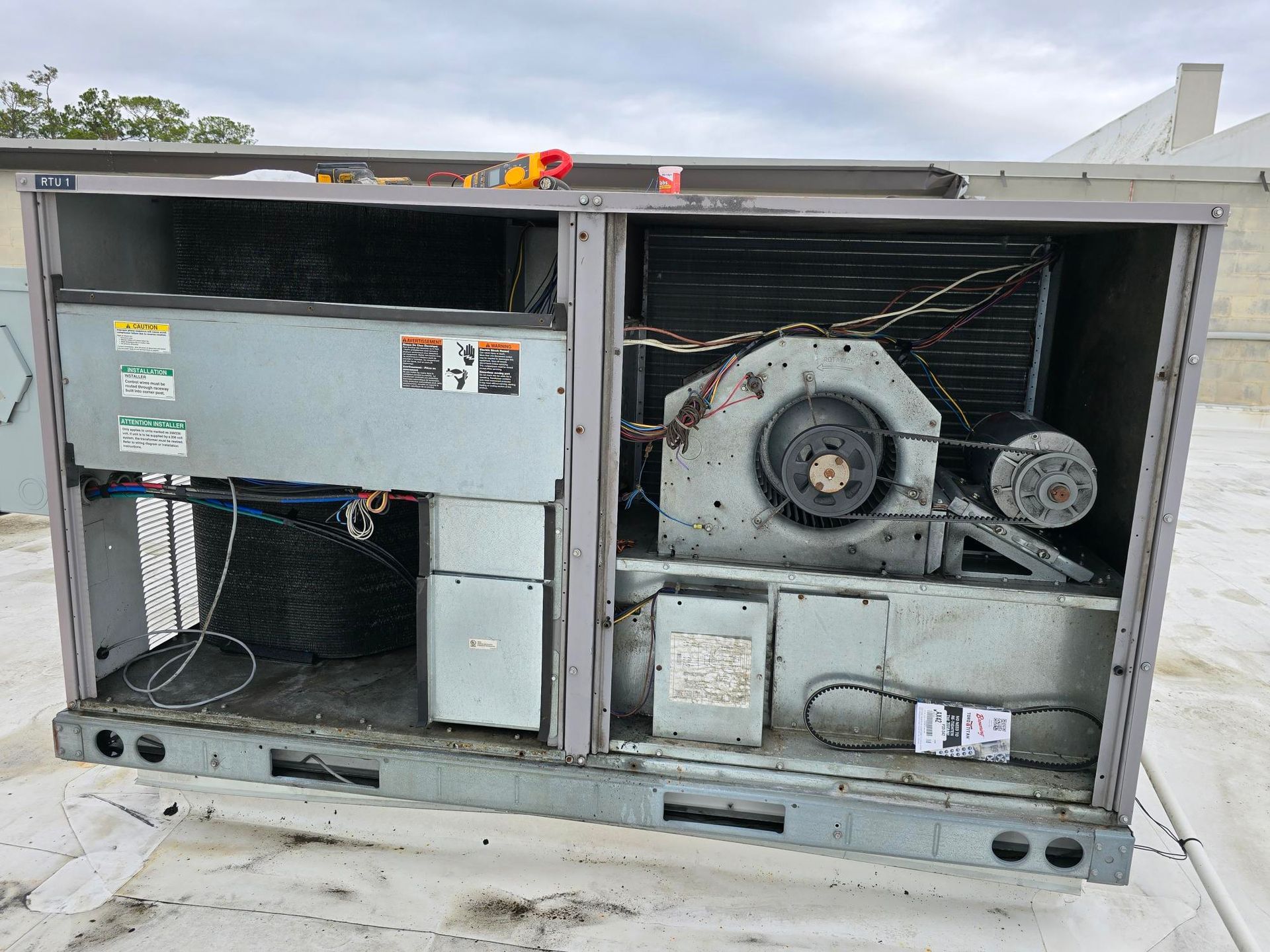 An old air conditioner is sitting on top of a roof.