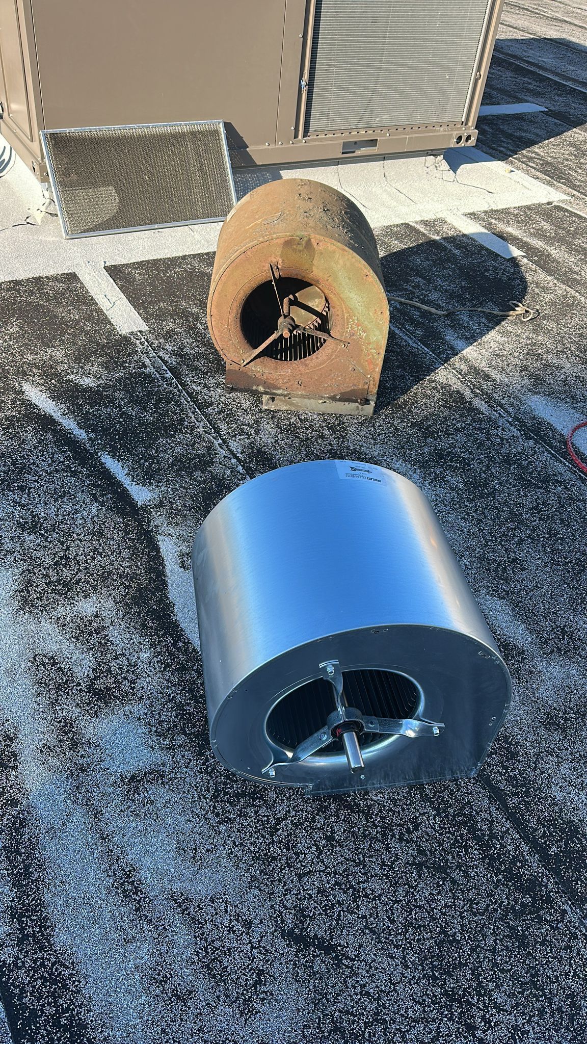 Two metal cylinders are sitting on top of a concrete surface.