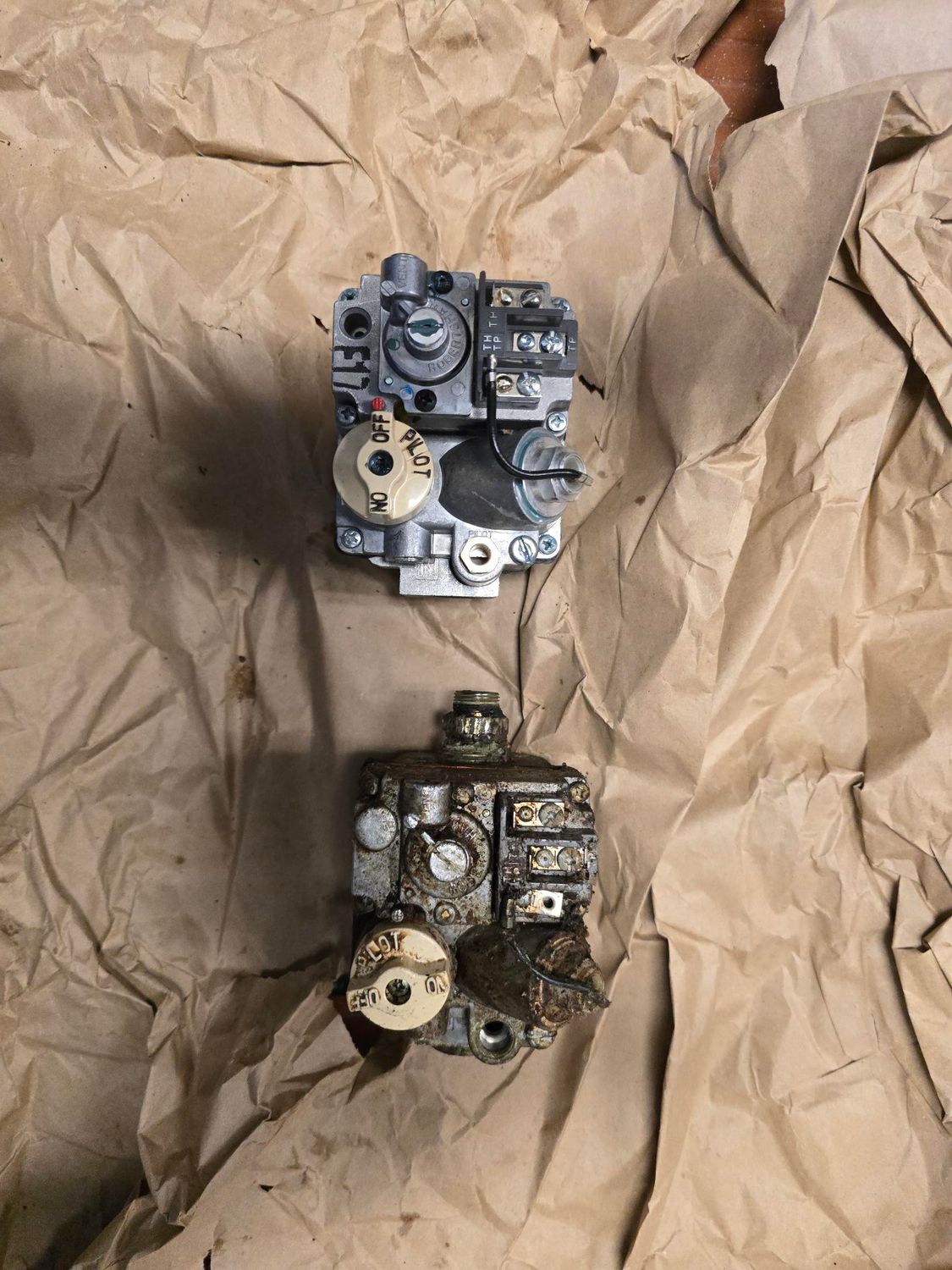 Two pieces of metal are sitting on top of a piece of brown paper.