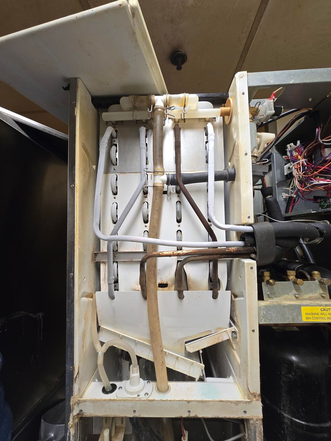 The inside of a refrigerator with a yellow warning sign on it