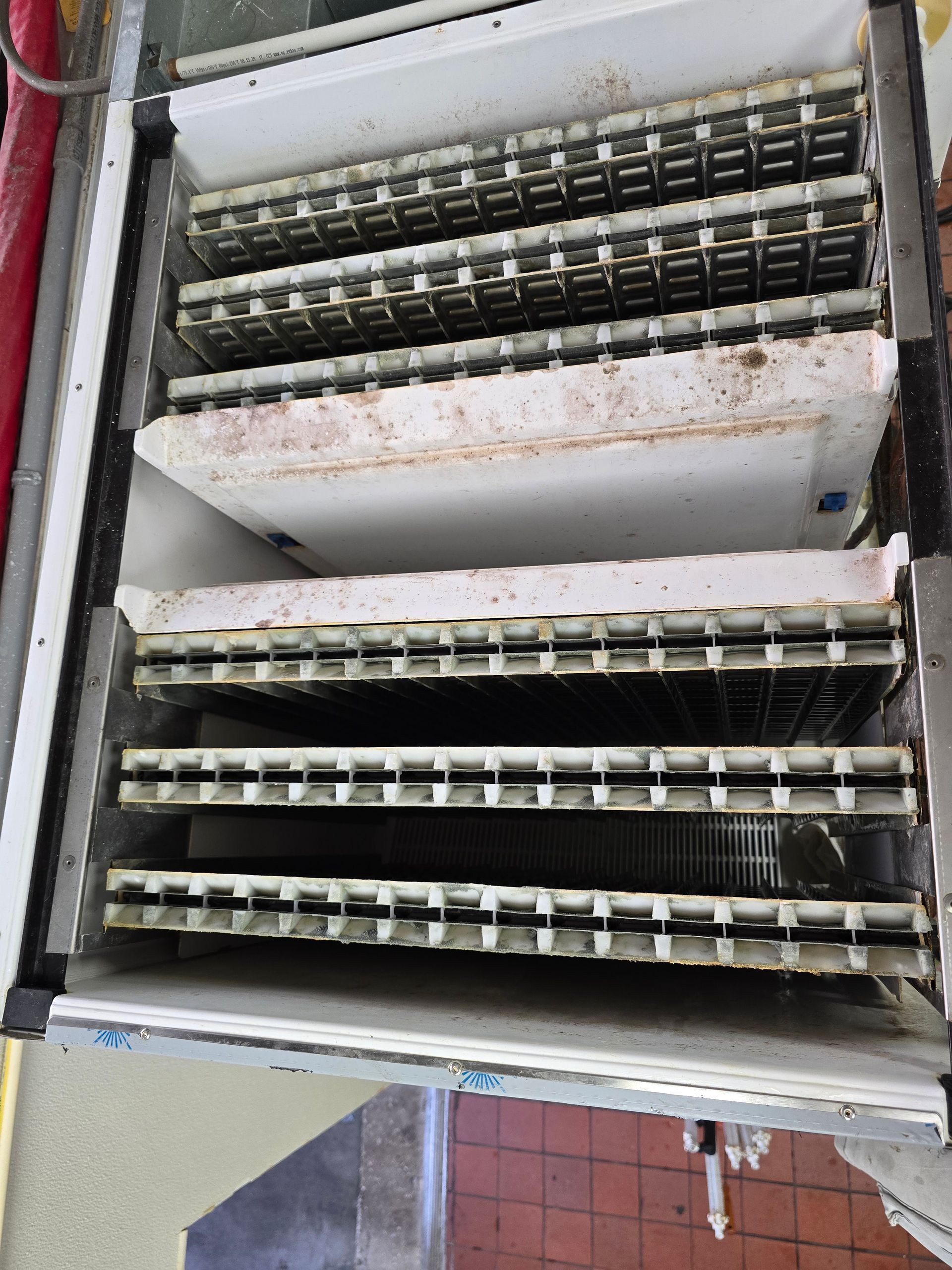 A dirty refrigerator with a lot of ice cubes in it