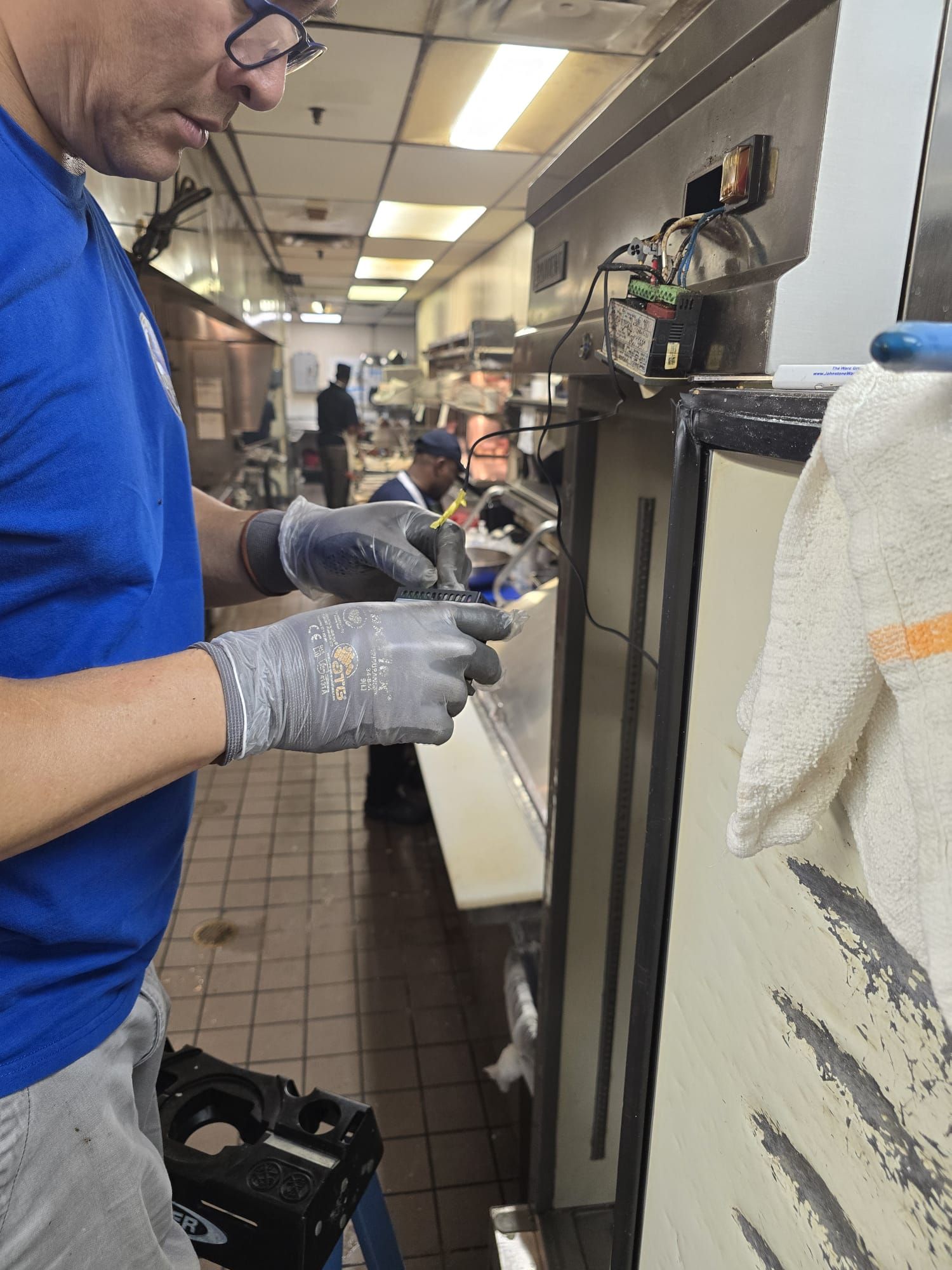 A man wearing gloves is working in a kitchen