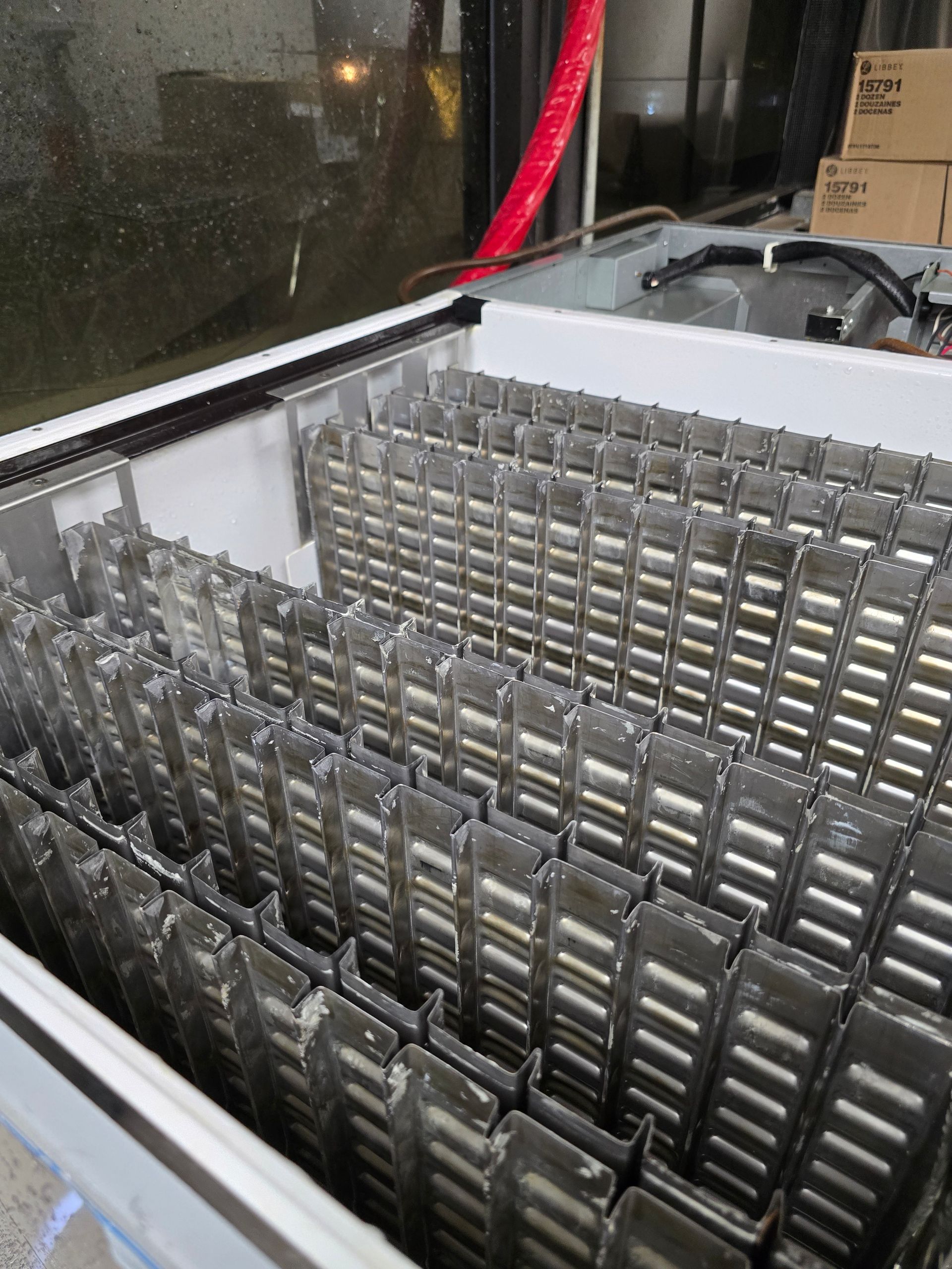 The inside of a refrigerator with a lot of ice cubes in it