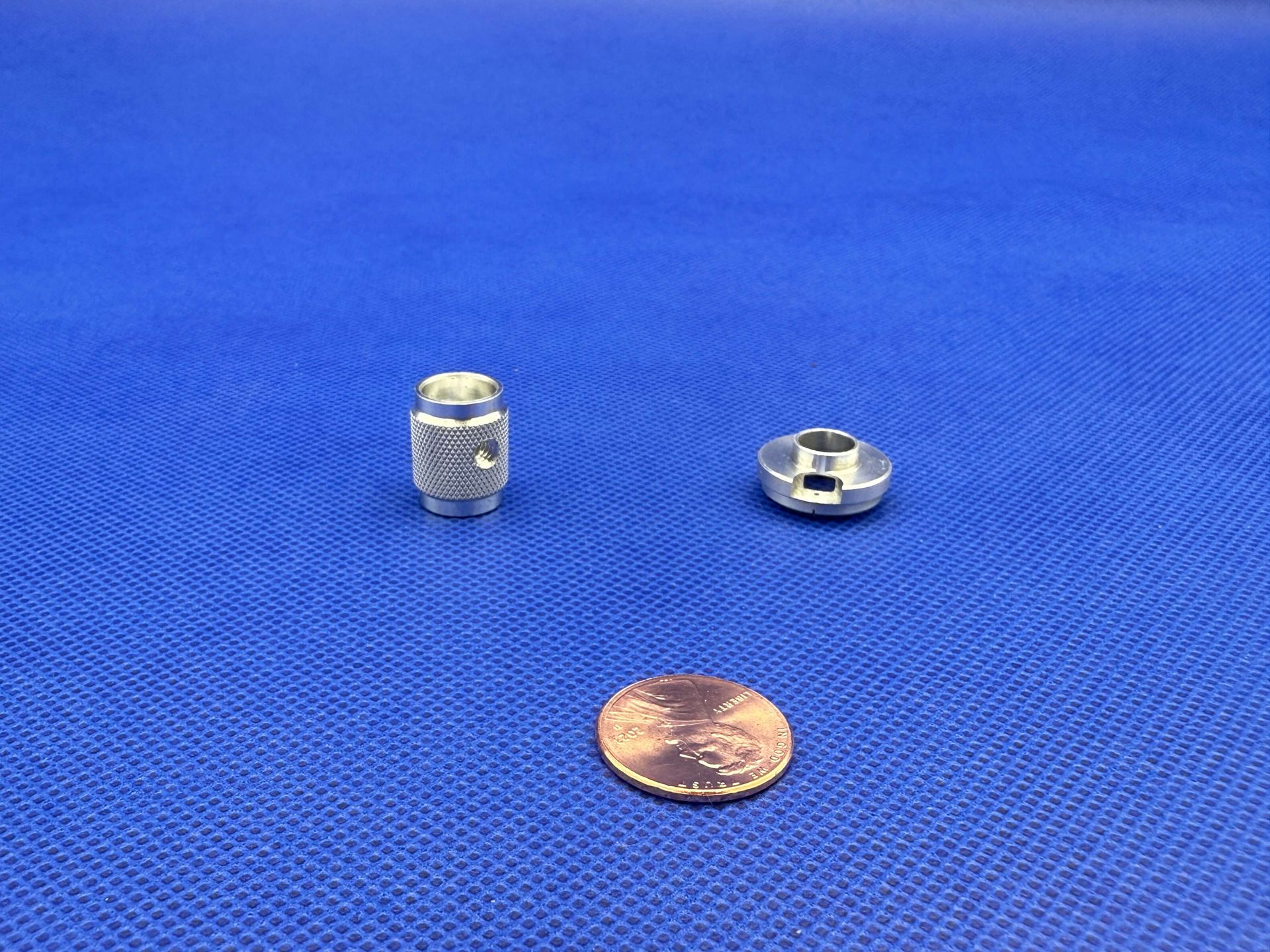 A bunch of aluminum rods are stacked on top of each other on a white surface.