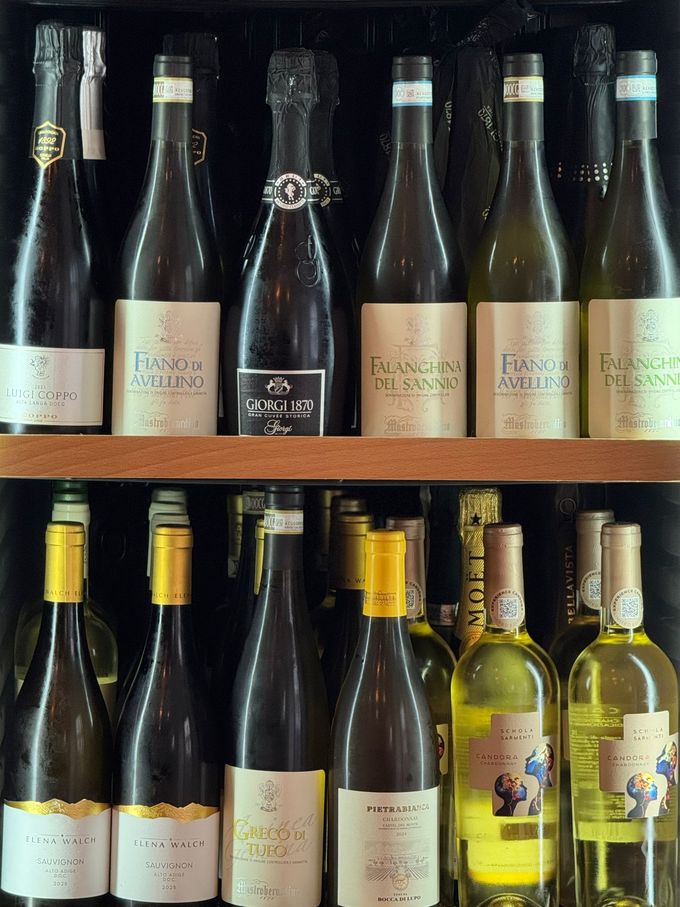 Forchetta che solleva spaghetti e cozze da un piatto bianco con salsa di pomodoro su un tavolo