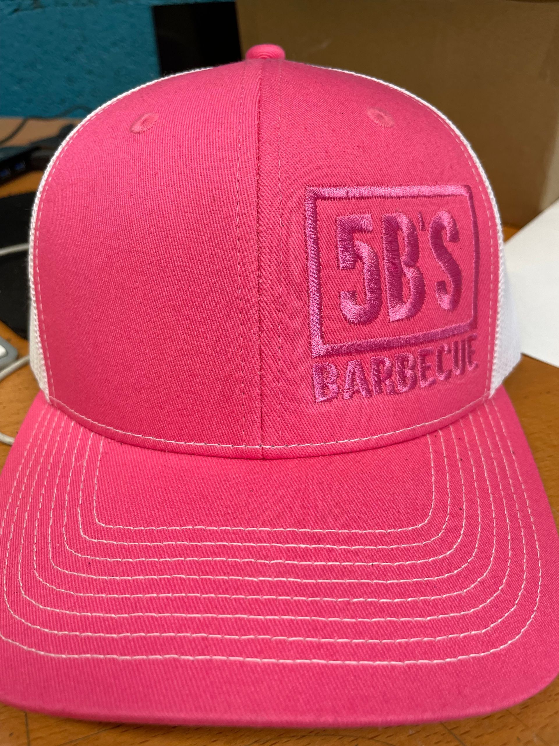 A pink hat with the word barbecue on it