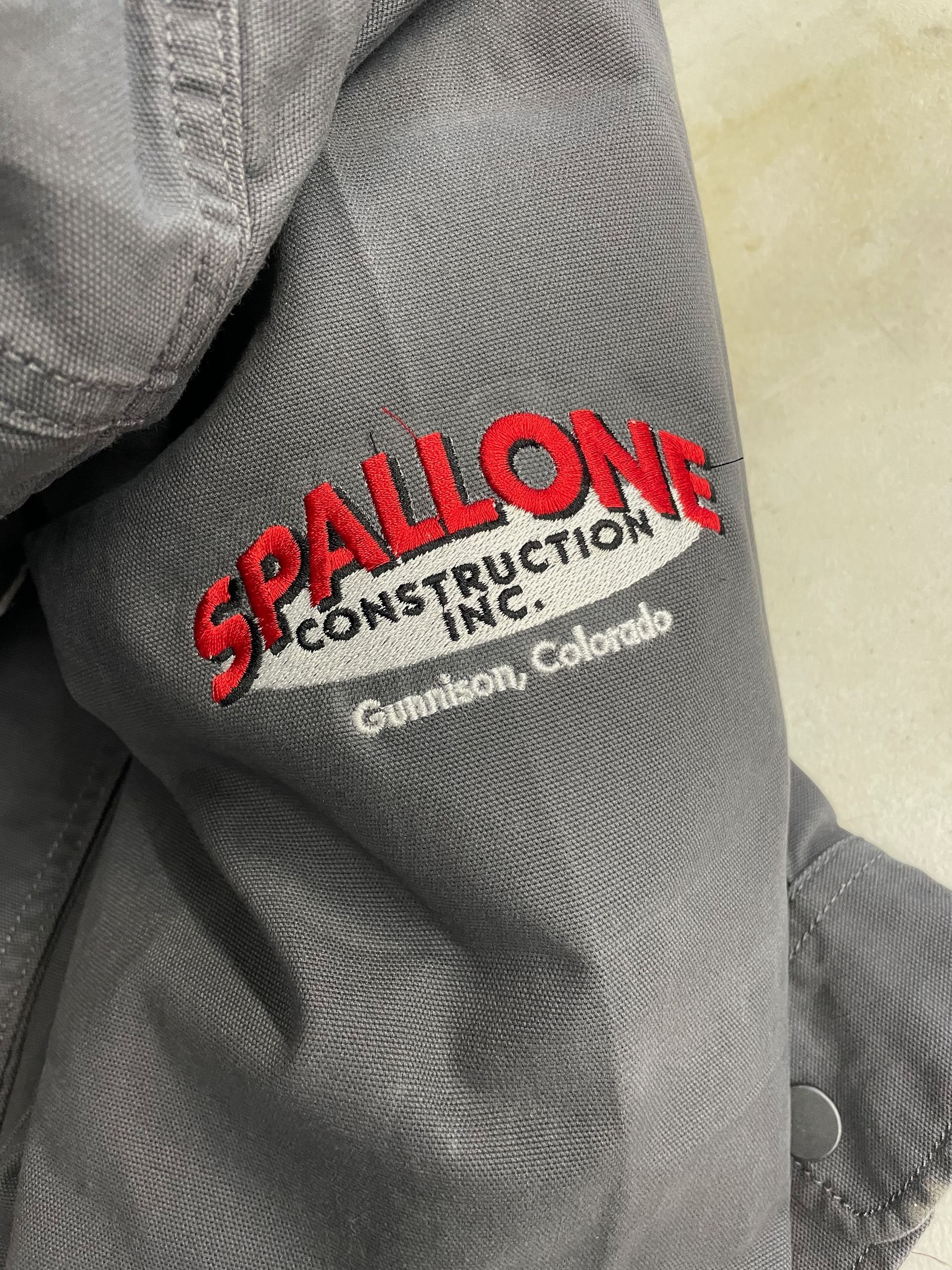 A close up of a jacket with the word spallone embroidered on it.