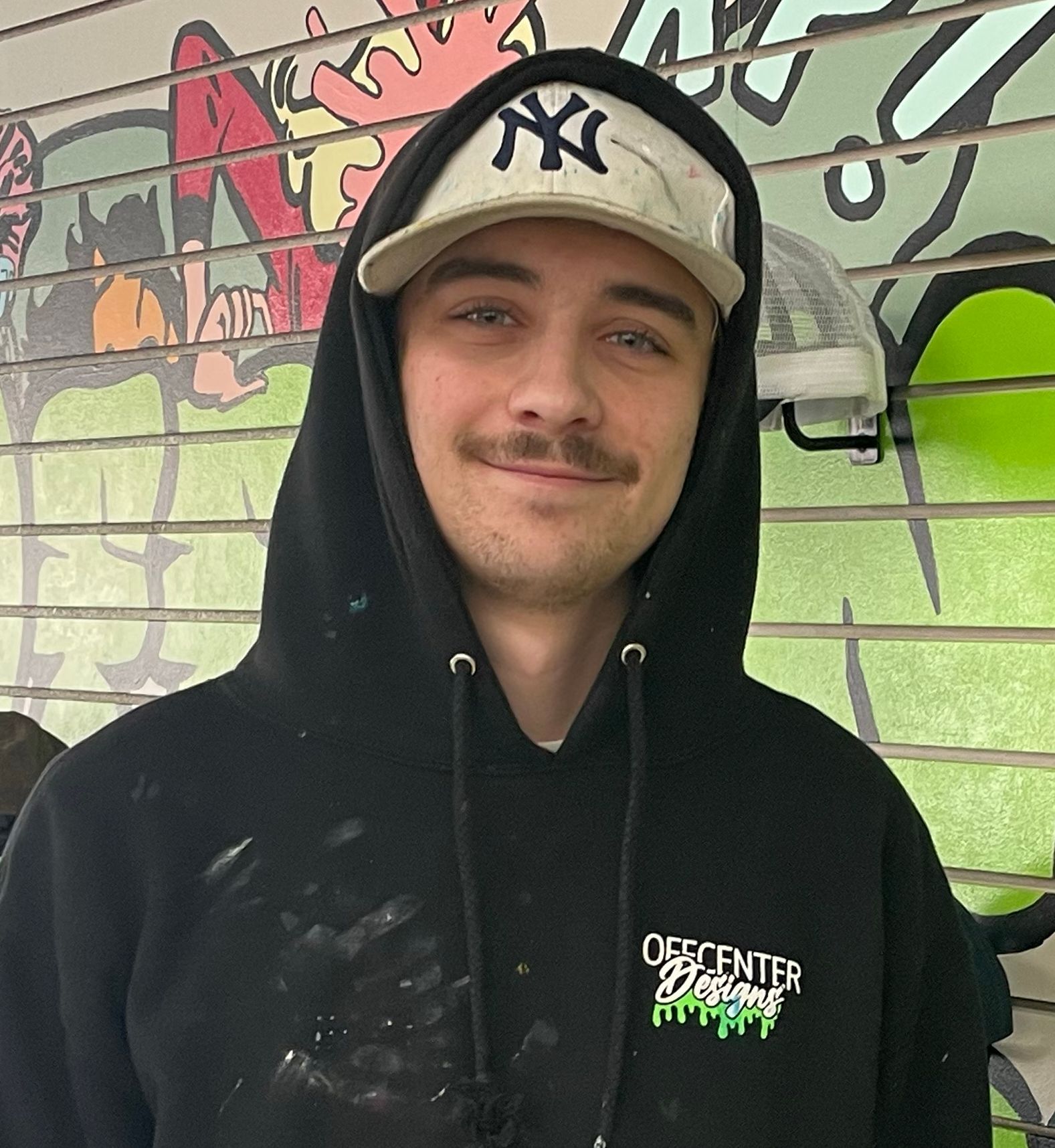 A man wearing a ny hat and a black hoodie