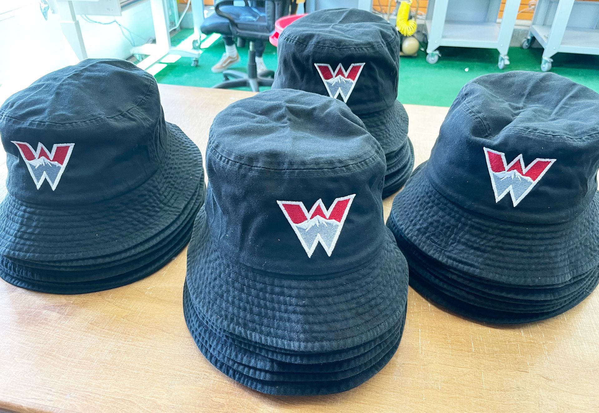 A bunch of black hats with the letter w on them