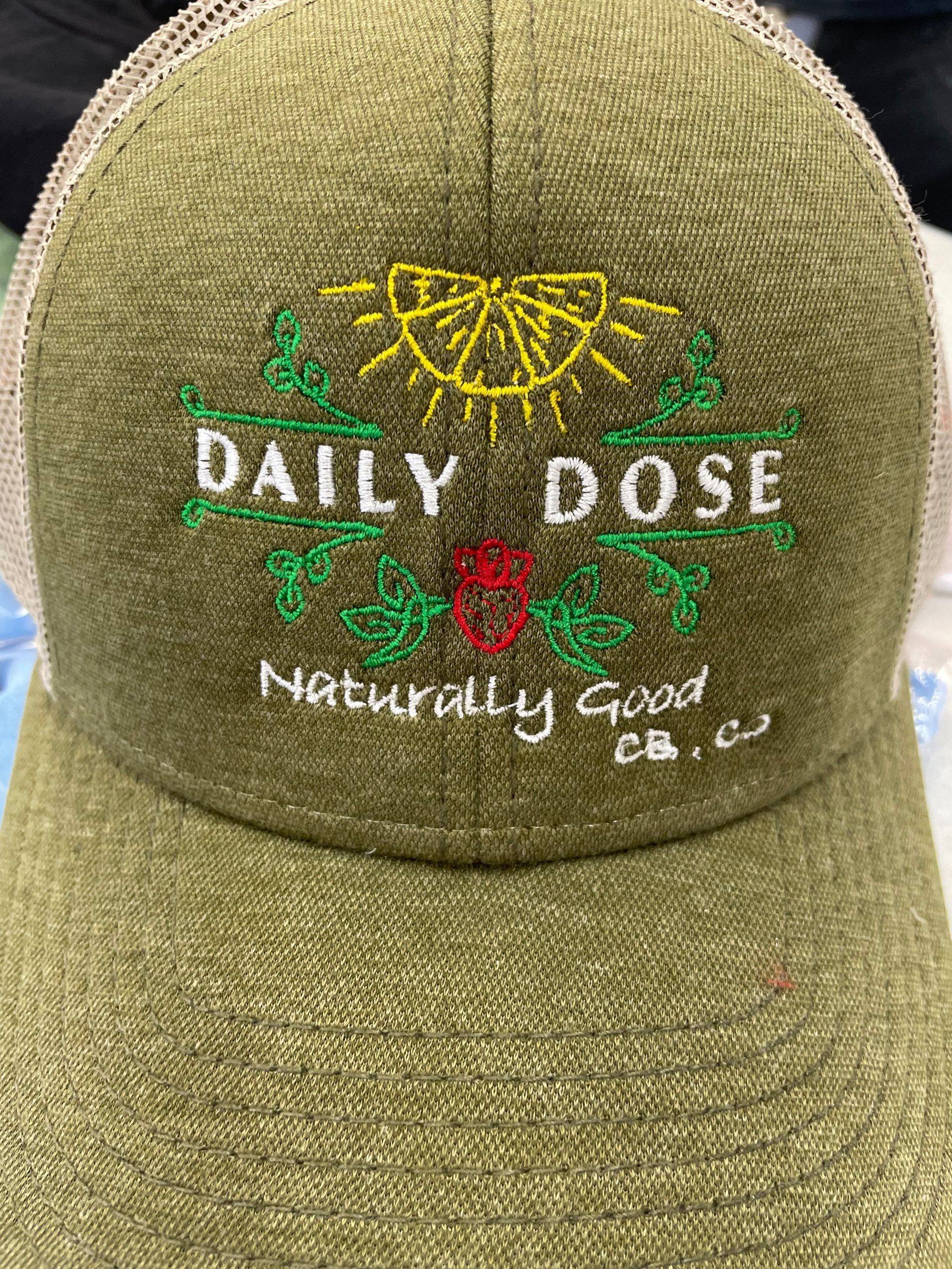 A green baseball cap with the words `` daily dose '' embroidered on it.
