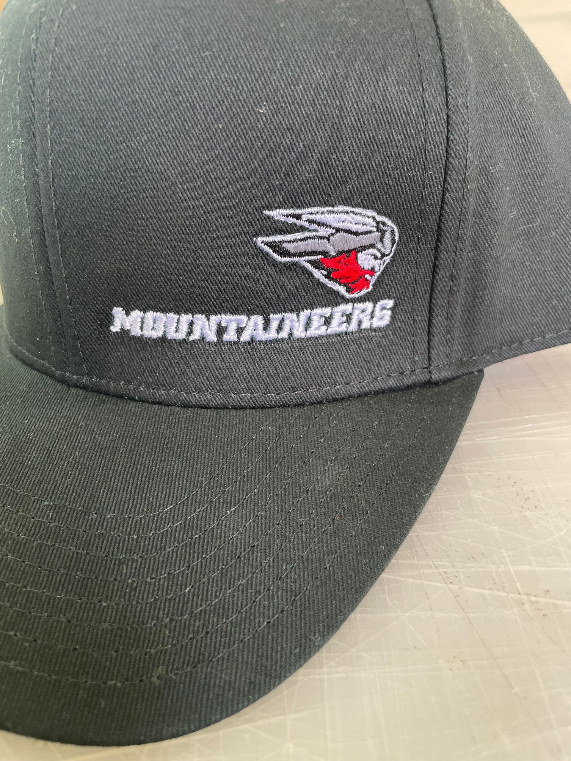 A black baseball cap with the word mountaineers embroidered on it.