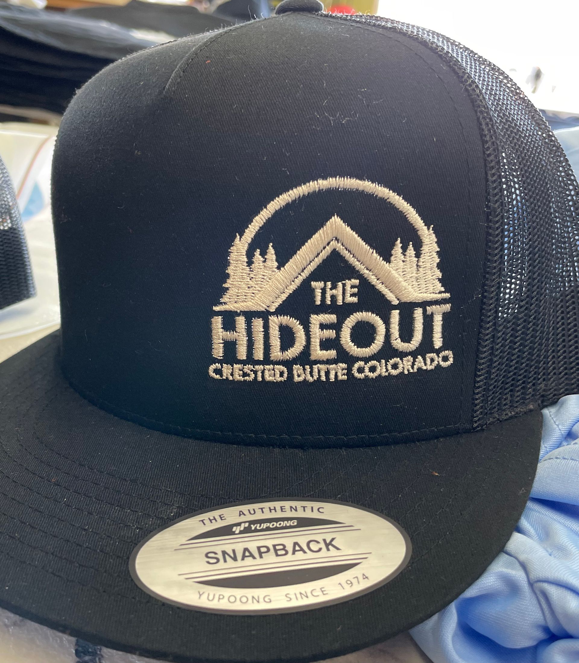 A black hat with the word hideout on it