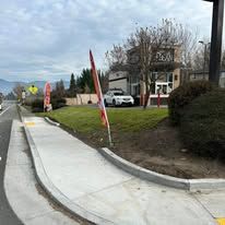 A car is parked on the side of the road next to a sidewalk.