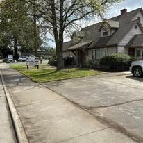 A house with a lot of cars parked in front of it.