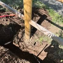 A person is digging a hole in the ground to plant a tree.