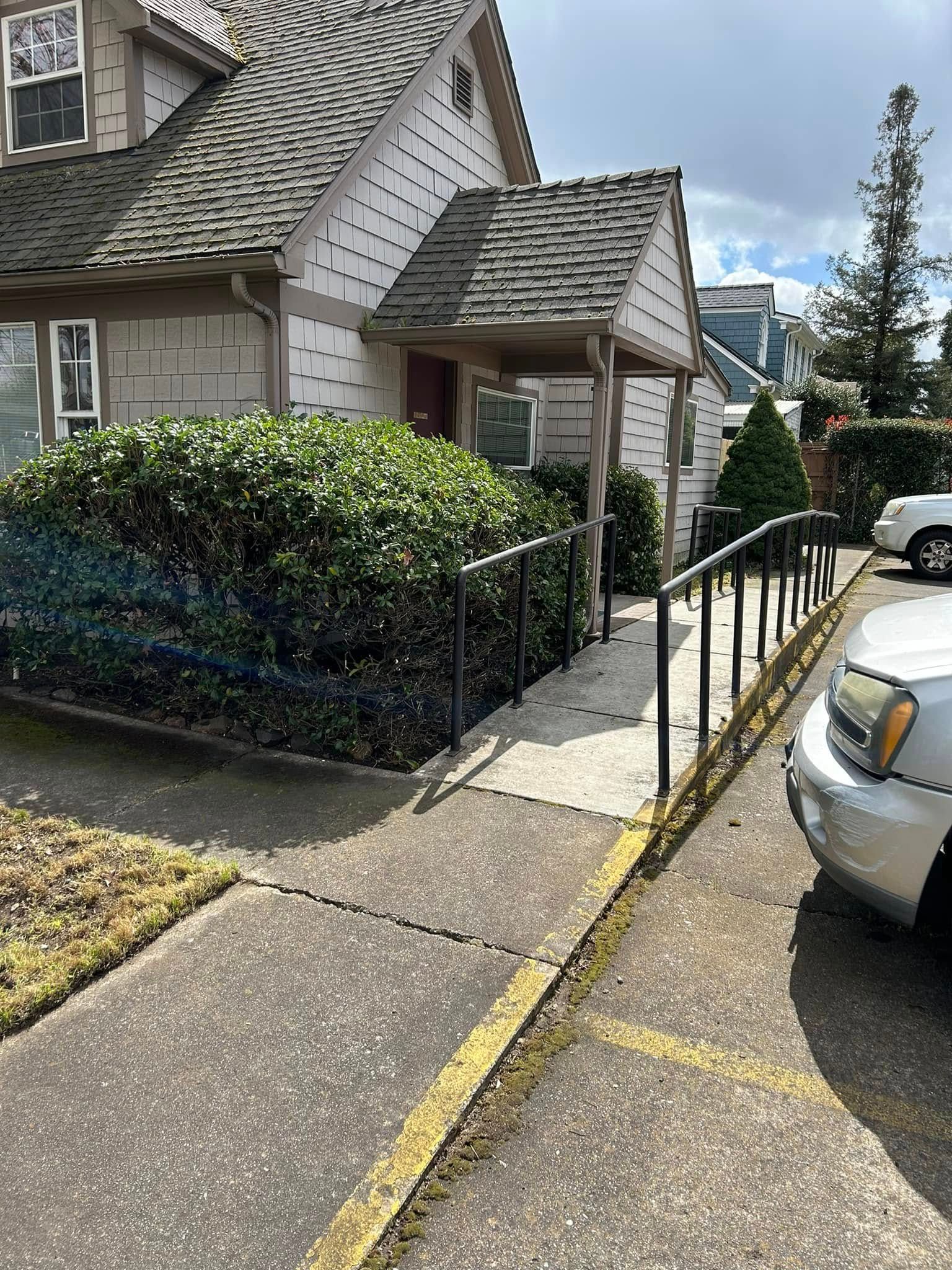 A car is parked in front of a house with a ramp leading to it.